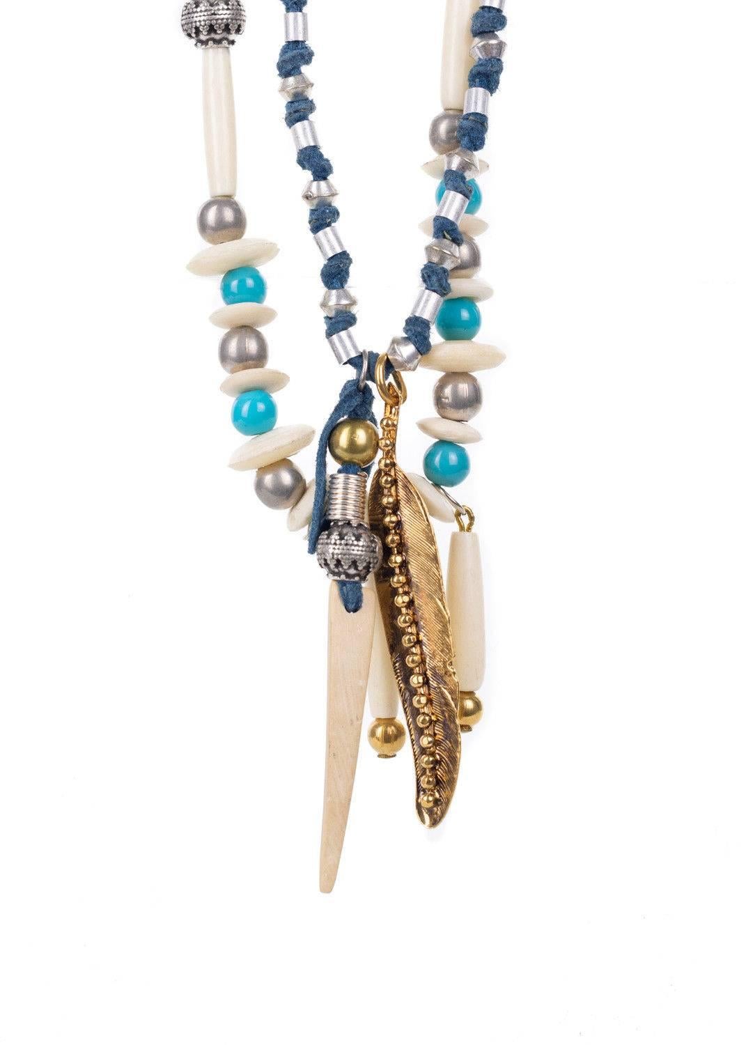 Get your Roberto Cavalli Necklace and add the perfect cultural touch to your ensemble. This necklace features a curbed chain, metal applique adorned blue fabric, metal beads and wood feather pendants. You can pair this necklace with an all white