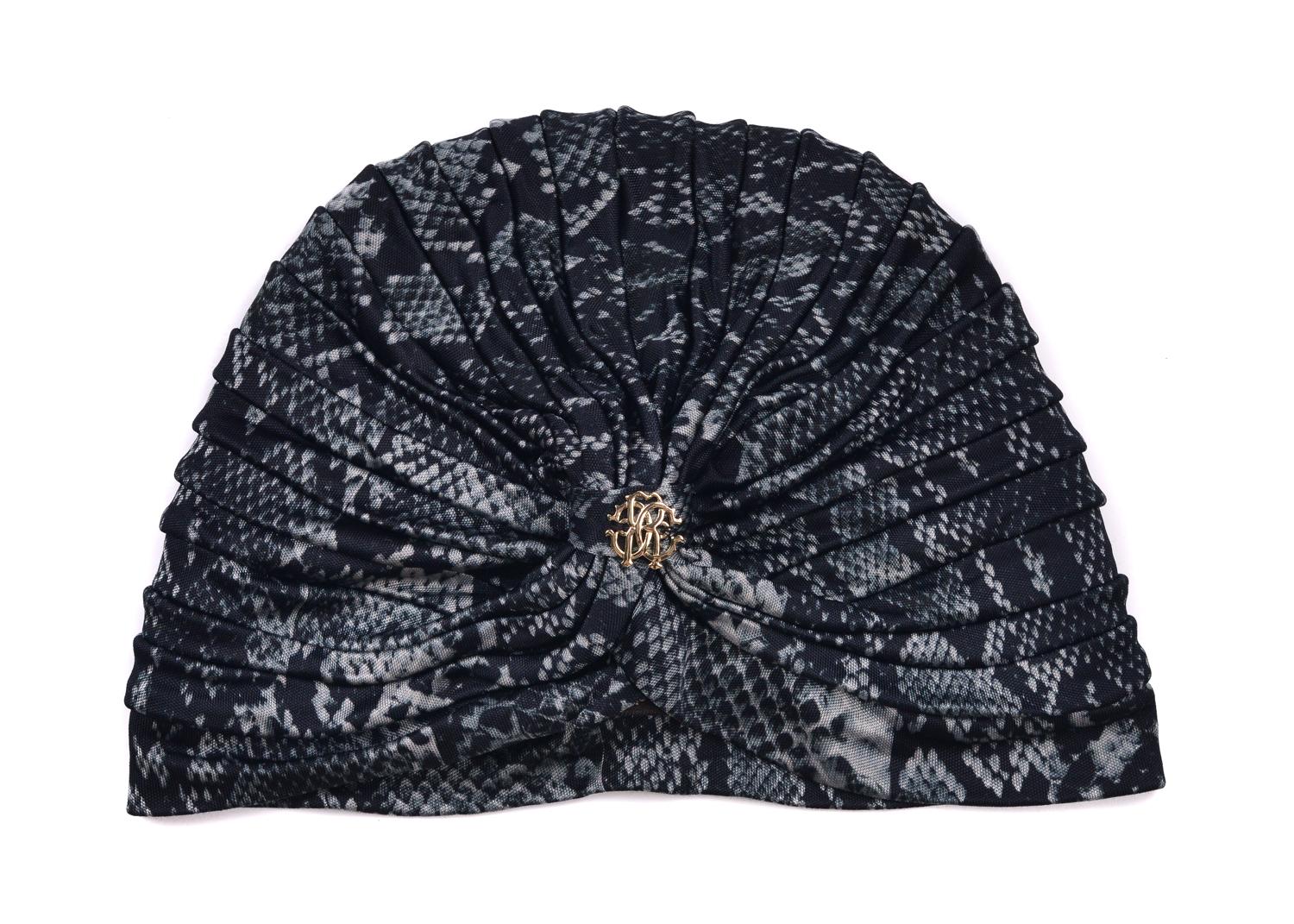 Be one with your wild artisan side with Roberto Cavalli's Snake Print Tiered Turban. This head piece features a grey and black snake print, centered gold RC Logo, and uniformly tiered body. You can dawn this evening beauty before or after that