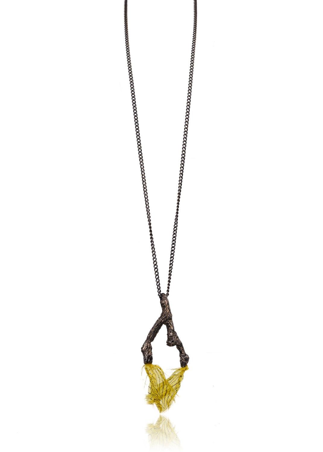 Explore your natural side with Roberto Cavalli's feathered branch pendant necklace. This earthy piece features an artistcally engraved double branch, yellow and blakc striped feather tips, and secured antique brass rope chain. You can pair this