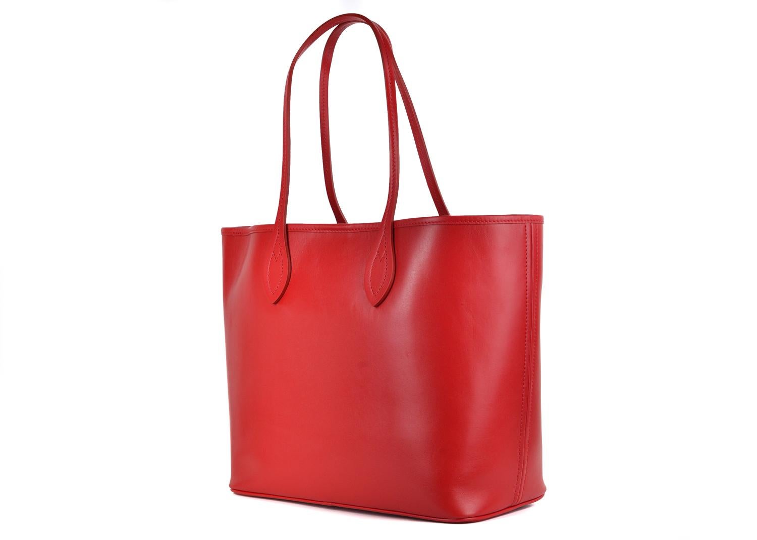 Roberto Cavalli red leather shopping tote bag. This tote bag features a grained leather finish in a beautiful Red color tone with contrasting gold tone hardware. This shopping bag is a great accessory for an everyday wear to store all your daily