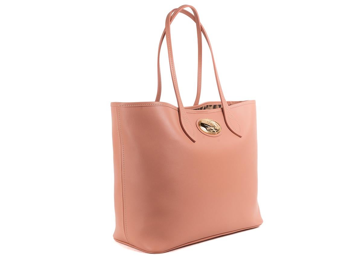 Roberto Cavalli Pink Leather Shopping Tote Bag. This tote bag features a leather textile in a beautiful solid pink color tone with contrasting gold tone hardware. This shopping bag is a great accessory for an everyday wear to store all your daily
