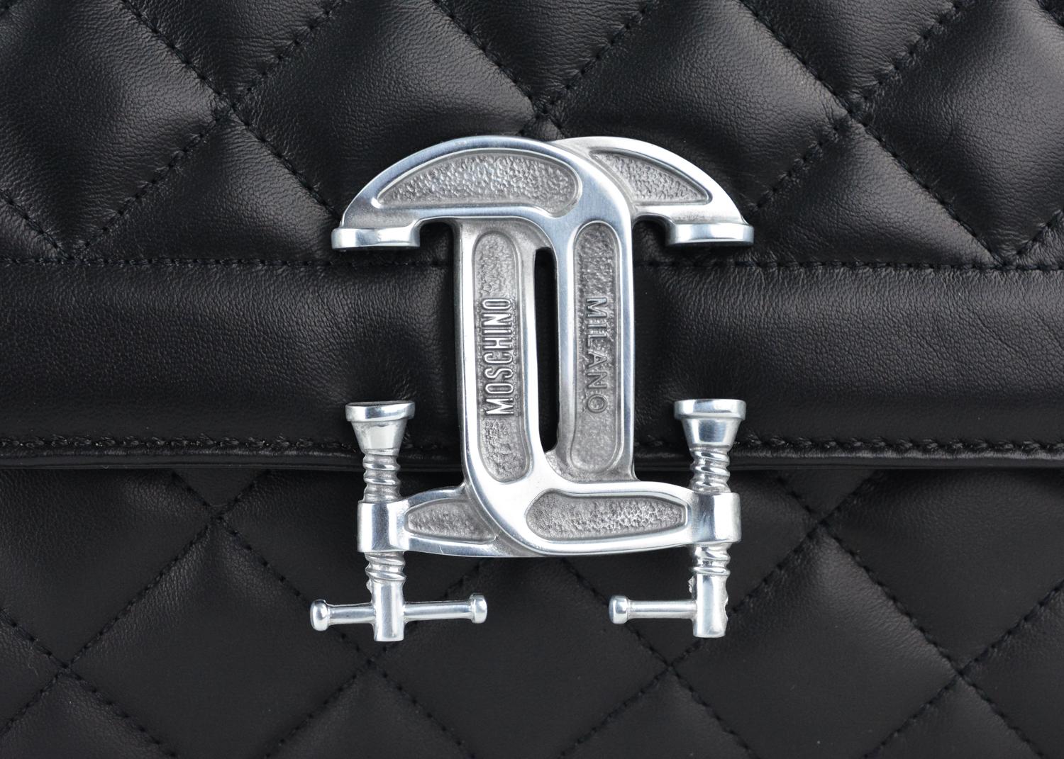Moschino black leather quilted shoulder bag. This bag features a silver tone hardware logo in the front. This shoulder bag is a classic silhouette that is great to wear as an everyday purse. Pair with an outfit for a chic everyday