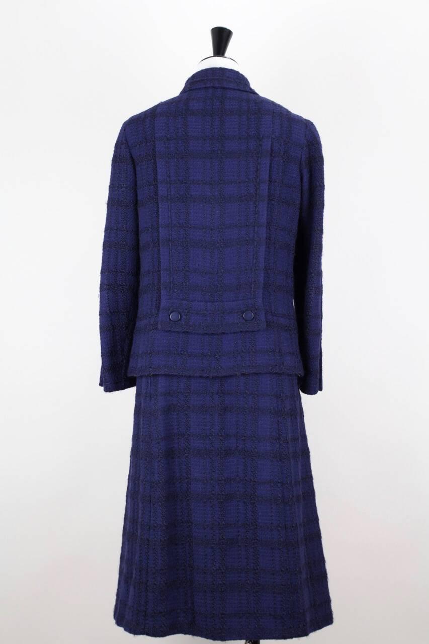 An absolutely stunning numbered Chanel Haute Couture jacket and skirt suit from Autumn/Winter 1971. Date has been verified by the House of Chanel.

This Chanel jacket and skirt suit is made from a soft black checked purplish blue bouclé wool. It is