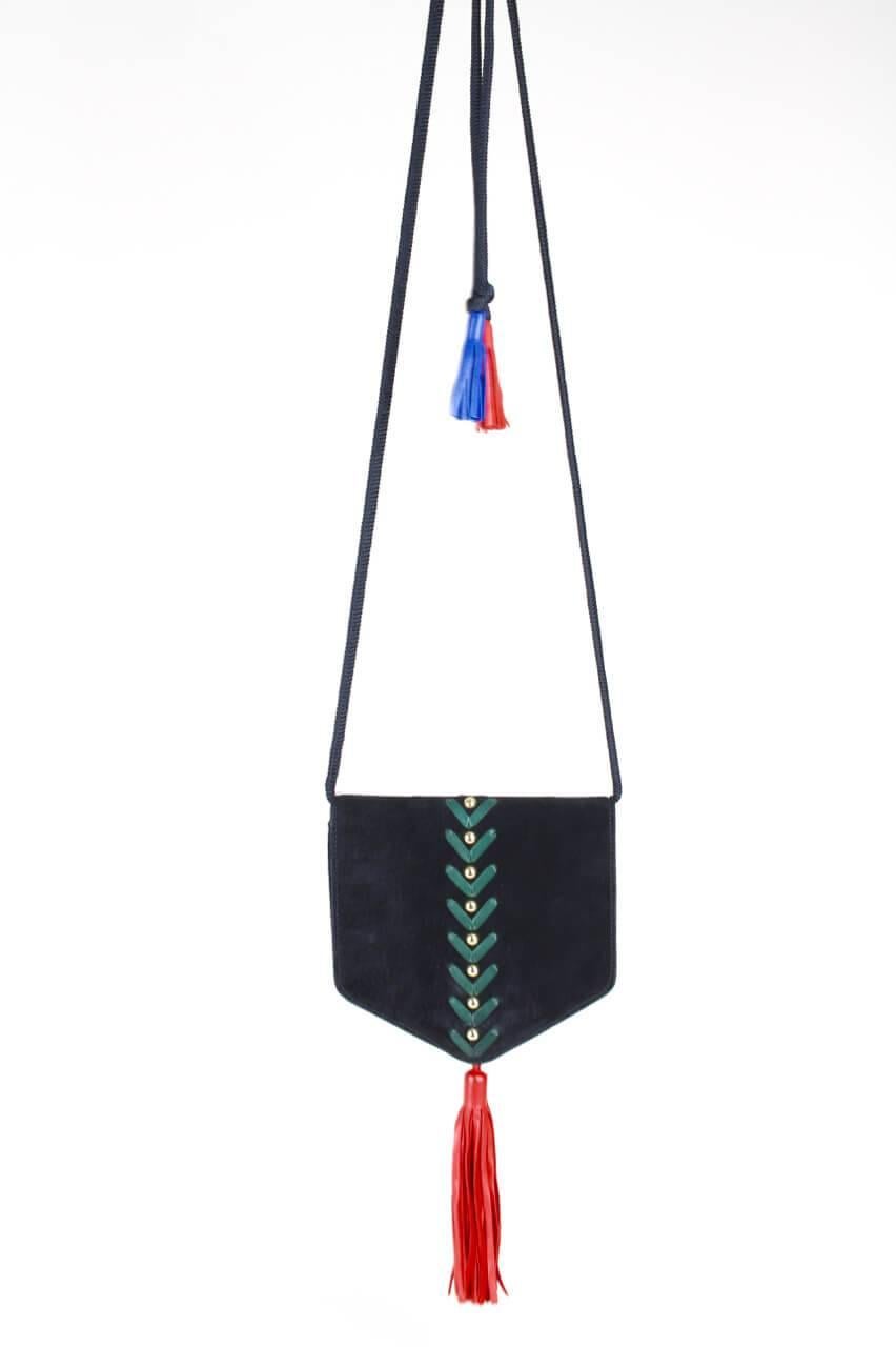 This adorable, rare Yves Saint Laurent pentagonal shoulder or crossbody bag is made from soft black suede featuring a racing green leather stitchery with gold-tone studs and an oversized ultra-supple leather tassel in bright red on the pointed flap.