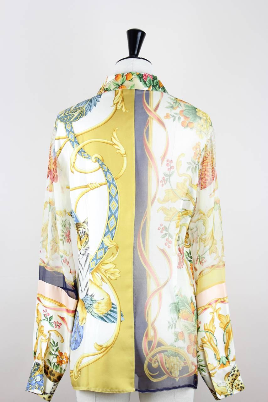 This multicolour blouse is made half and half from silk twill and sheer silk chiffon and features a floral print with wild animal motifs. It is collared and long sleeved with mother of pearl buttons. The buttons show the Salvatore Ferragamo