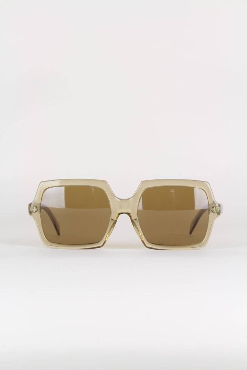 These high-quality 'Tofana' sunglasses feature a slightly oversized translucent taupe hexagonal frame with its original light brown medium tint square glas lenses. They are made in Germany and marked 