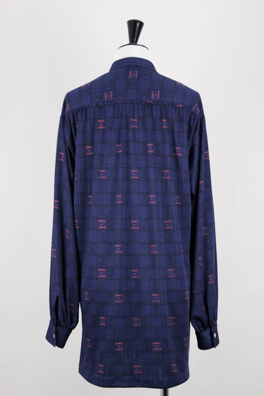 This navy blue stretch jersey tunic features an unusual black geometric hourglass-like motif and a red logo print 