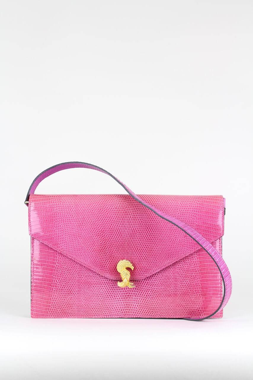 This envelope style clutch bag or shoulder bag is made from pink-hued carefully matched strong exotic lizard skins. It features a front flap with a gold-tone clasp closure designed like a bunch of knotted cords and a detachable shoulder strap in
