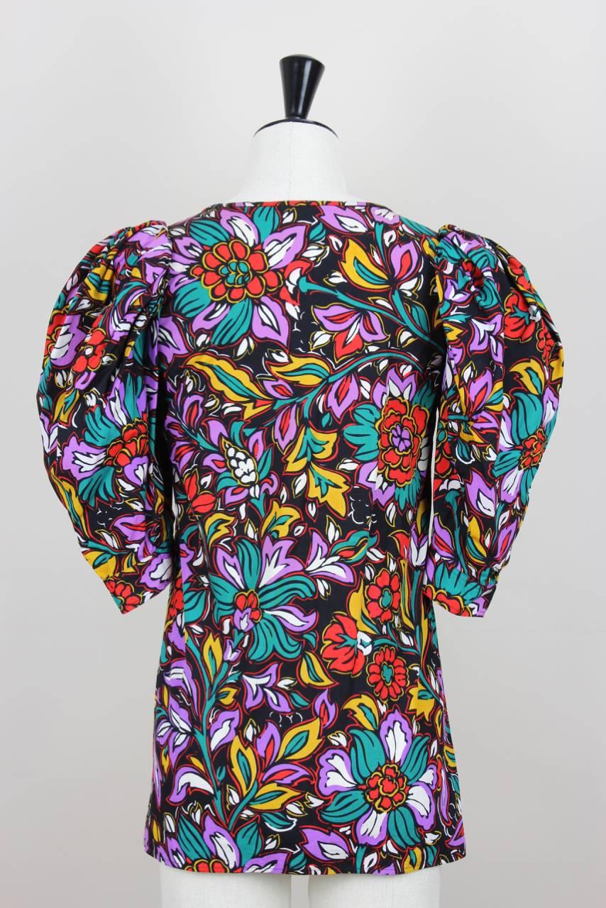This floral pattern paesant style blouse in vibrant colours features a low cut scoop neckline and exaggerated half-length puff sleeves with buttoned cuffs. It is made from pure cotton poplin and has no zipper. This blouse has the added provenance of