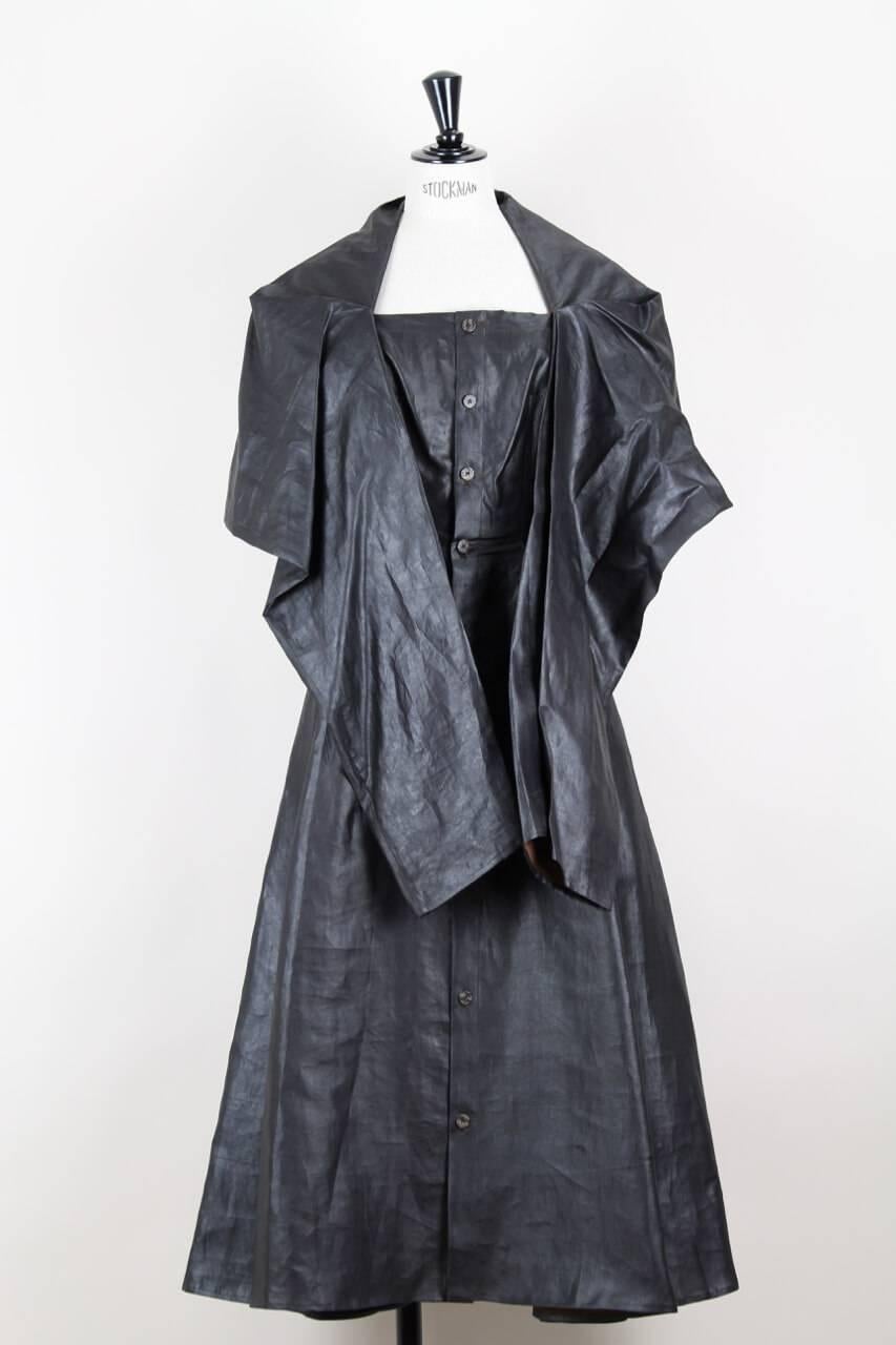 This minimalist yet feminine draped midi dress is crafted from a lustrous charcoal grey coated rustling silk. The sleeveless piece is fitted in the bodice (darts at bustline), with an A-line skirt and features a buttoned front. The draped