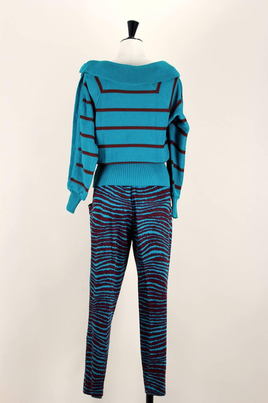 This two-piece set consists of a teal green and maroon striped knitted jumper and high-waisted colour-coordinated zebra stripe-esque patterned trousers. The pullover is made from high quality cotton, tagged 