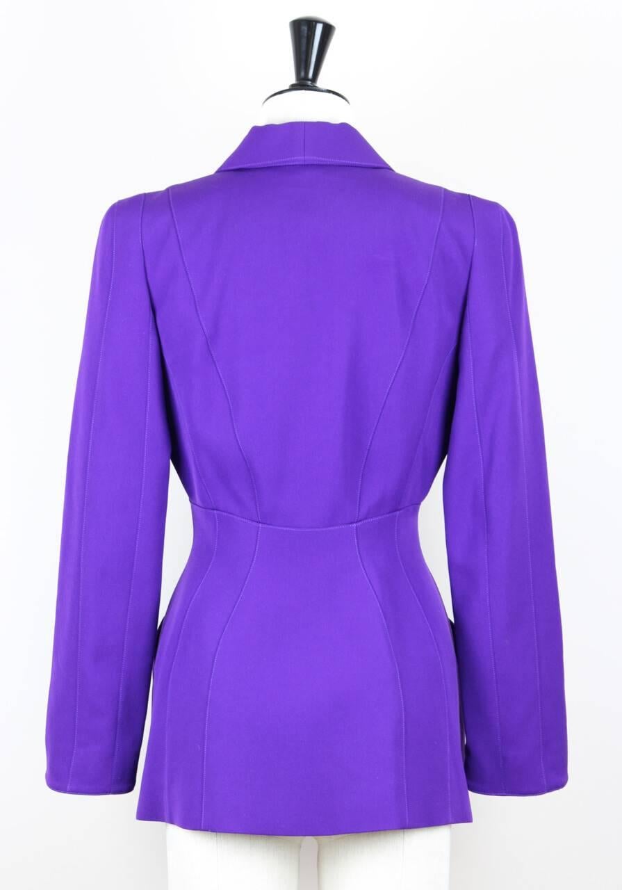 This purple virgin wool jacket features a V-neckline with collar, a beautifully tailored waistline, two front pockets, long sleeves, shoulder pads and fastens with four concealed snap buttons. It is fully lined.
 
Excellent vintage condition. The