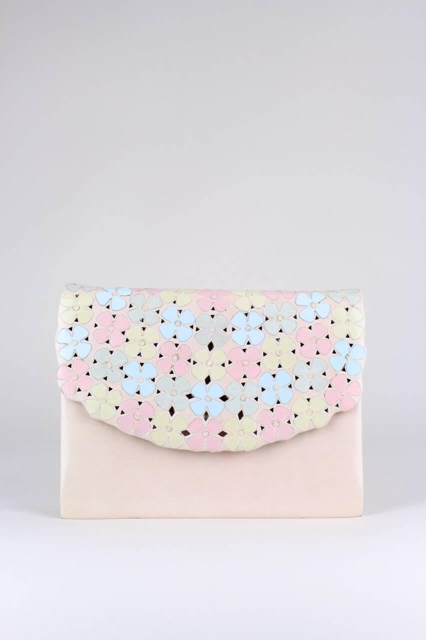 This bag is made from beautifully soft kid leather in pale pink. The fold-over front flap features cut-outs and is allover appliquéd with leather blossoms in diverse pastel colours. The bag has a long matching detachable shoulder strap, is fully