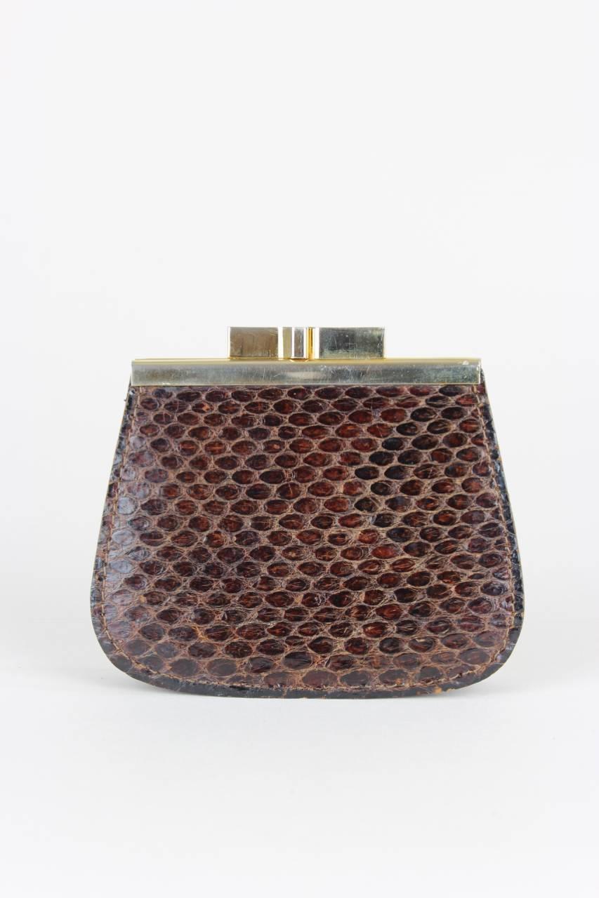 This chocolate brown snakeskin pattern leather coin purse features a gold-tone metal frame, the Pierre Cardin logo on the front and a top kiss lock closure. The dark brown leather interior shows two compartments and a small slip pocket in between.
