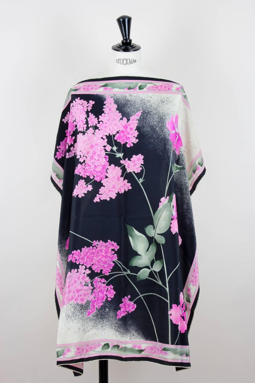 This fabulous silk scarf features a vibrant lilac and pink floral print with silvery-green leaves on a black to cream colour gradient background. It has a hand-rolled hem and is signed 