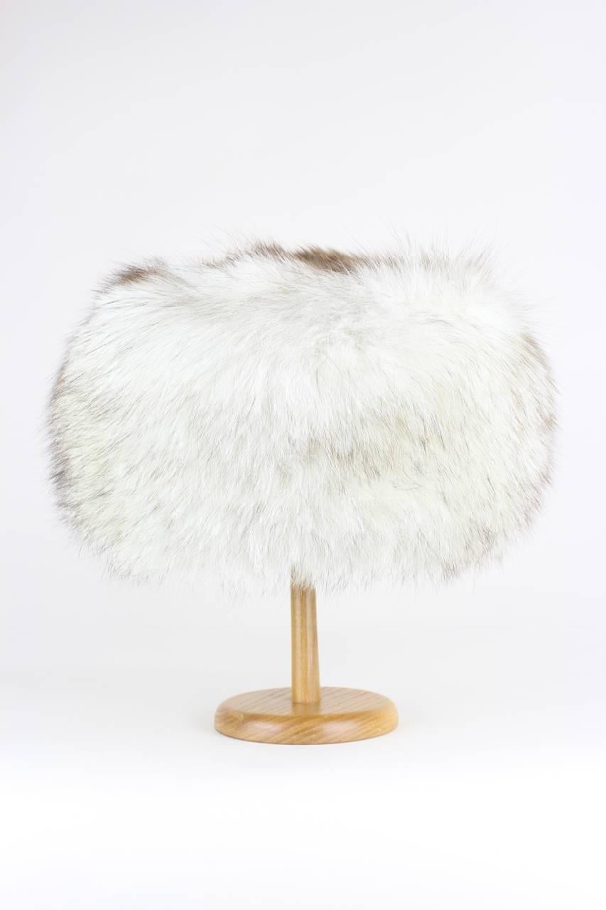 This Finnish amazing Nordic princess style hat is made from real arctic fox fur, in the traditional whites and creams with smokey brown guard hairs. The fur is very thick and fluffy and runs around the head. The top is made from another
