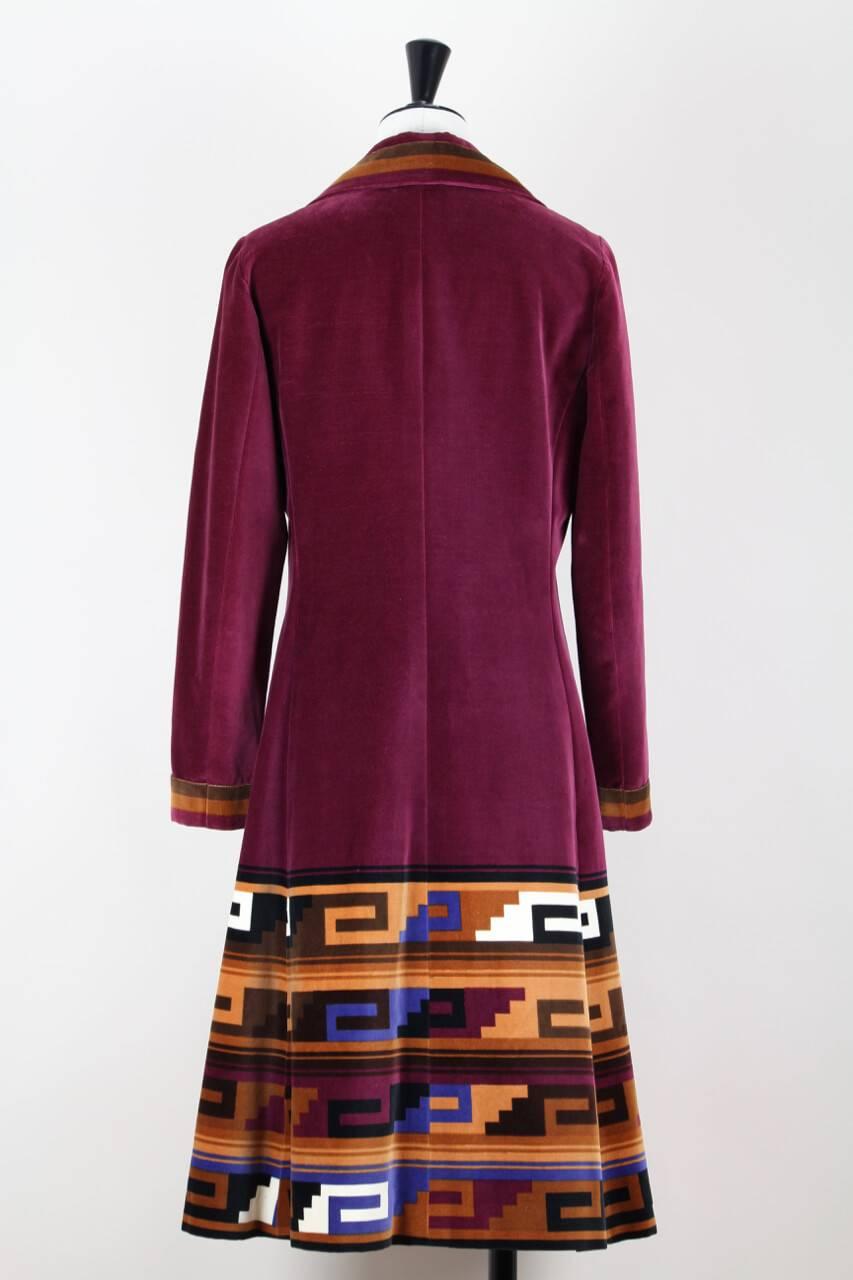 This outstanding 1970s Roberta di Camerino coat is made from soft ruby velvet with a beautiful Aztec print in burnt orange, brown, caramel and vibrant blue. It features a four point collar, darts at the bust, two side seam pockets and flares