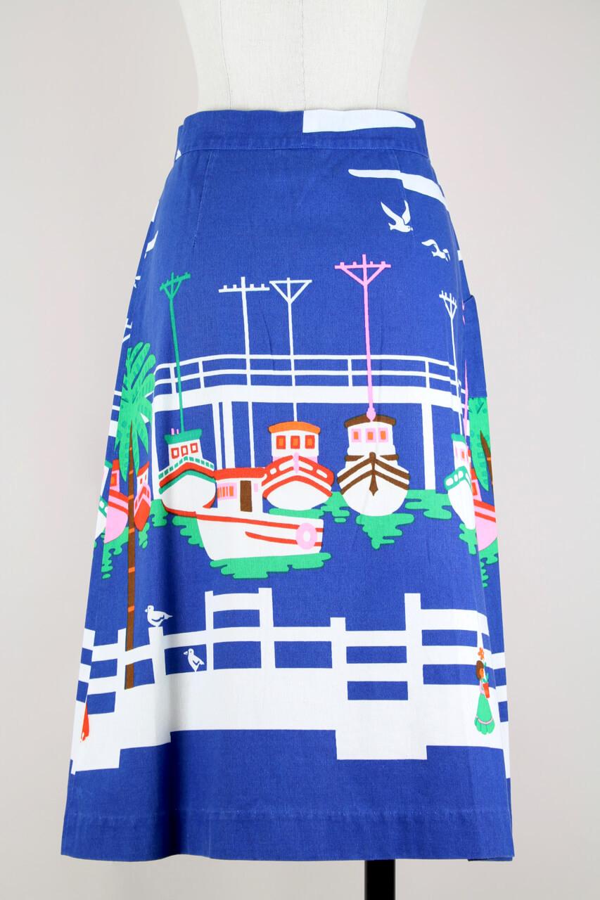 A charming & sophisticated 1970s Malia of Honolulu Hawaiian deep cobalt blue wrap A-line skirt. The skirt features a unique nautical screen-print of sea birds and colourful ships docked in the harbour on a high-quality cotton. It has one patch