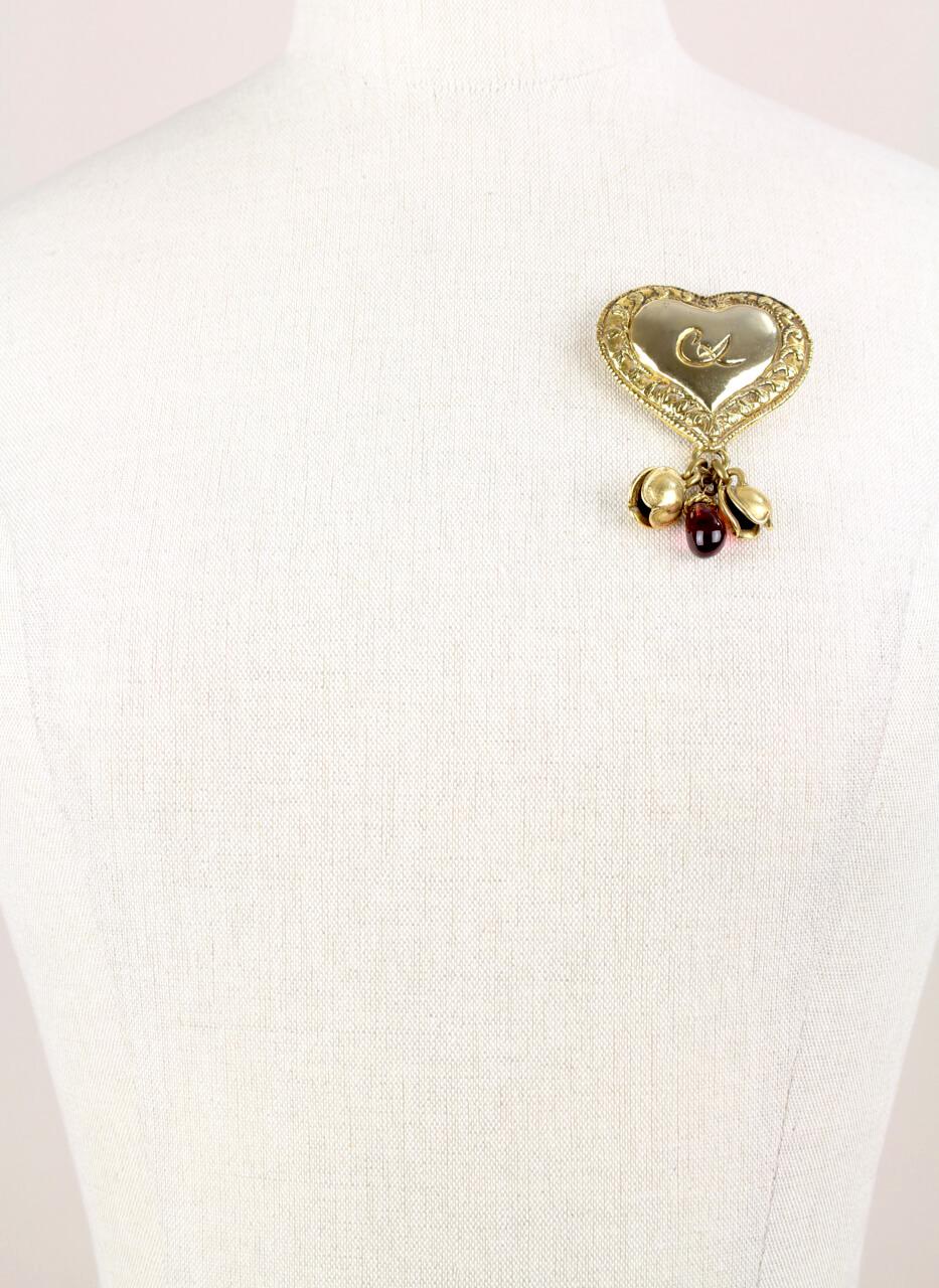 A large late 1980s/early 1990s statement heart-shaped perfume holder brooch with dangling charms by Christian Lacroix.

Christian Lacroix's line of statement jewelry features romantic motifs – from hearts to roses and seashells. The designer’s