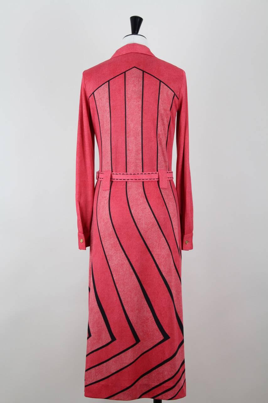 This pink and lobster-red belted polyester knit dress comes directly from the Roberta di Camerino archive in Italy (see archive's stamp on picture 8) and is therefore unworn. 

Dress and belt show an illusionistic print with black detailing adding