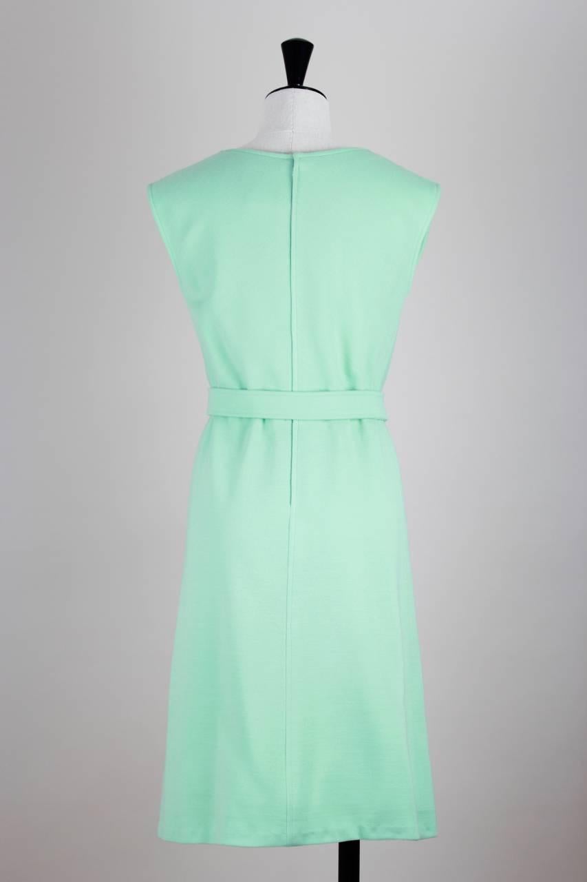 This, c. early 1970s, minimalist André Courrèges belted dress features the characteristic clean cut and comes in a fresh sea green.

The design has a round neck, rounded shoulders and the signature Courrèges logo embroidered to the center front