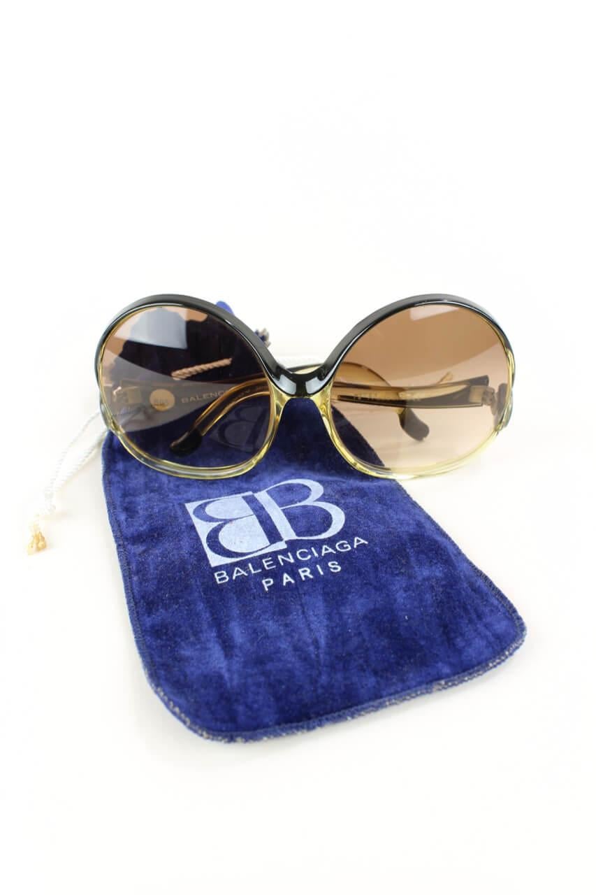 Outstanding 1970s Balenciaga model 7697 black to clear oversized sunglasses holding a spotless pair of brown gradient plastic lenses. Designed and produced in France. The frame is signed 