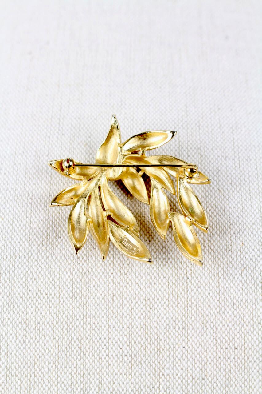 Beautiful Crown TRIFARI stylized marine plant brooch from the 1950s/1960s. The gold toned brooch features arched highly textured stippled leaves and closes with a secure roll over clasp at back. It is signed 