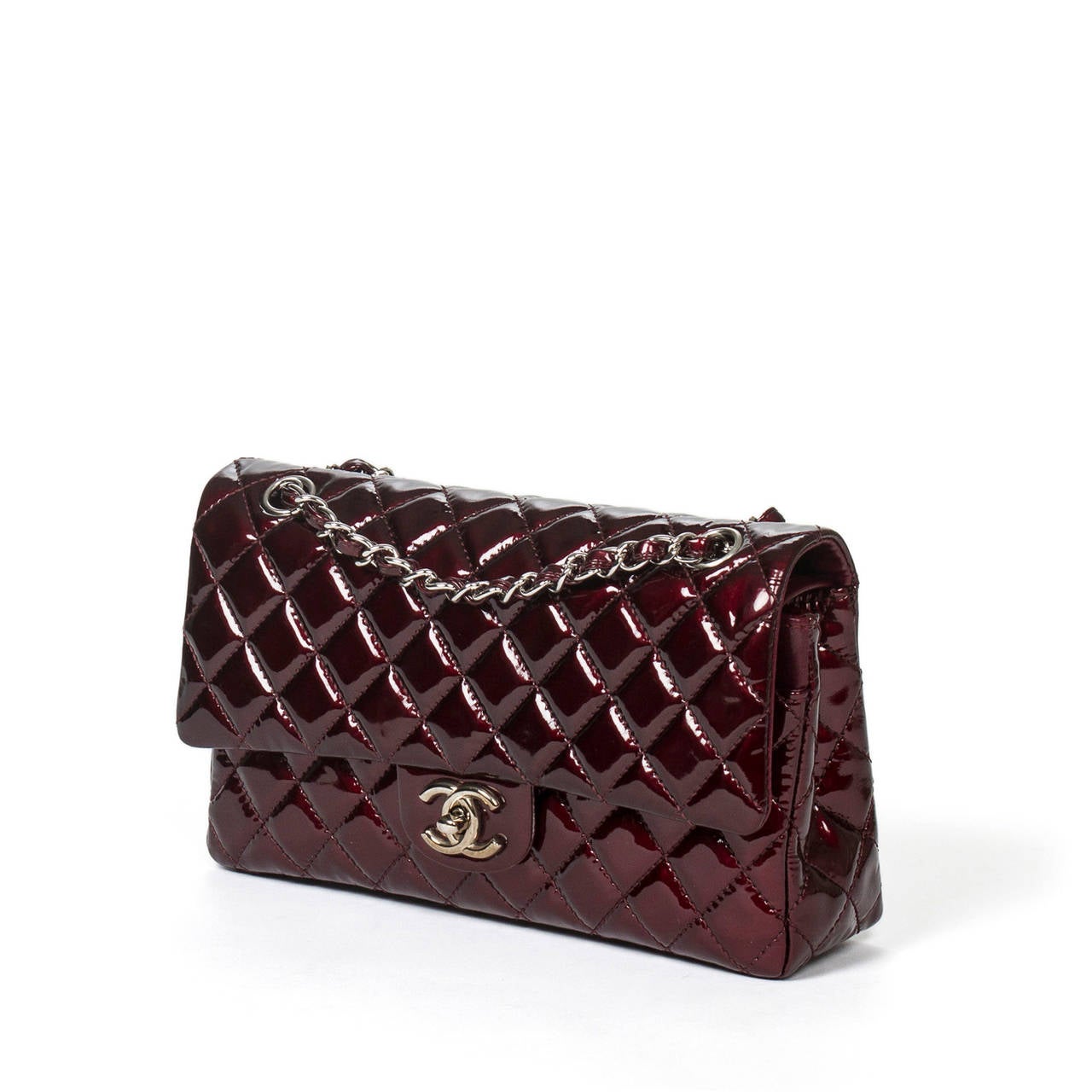 Classic flap in metallic burgundy quilted patent leather, double flap, double chain strap interlaced with leather, CC turnlock, slip back pocket and silver hardware. Burgundy leather lining with 3 slip pockets.
