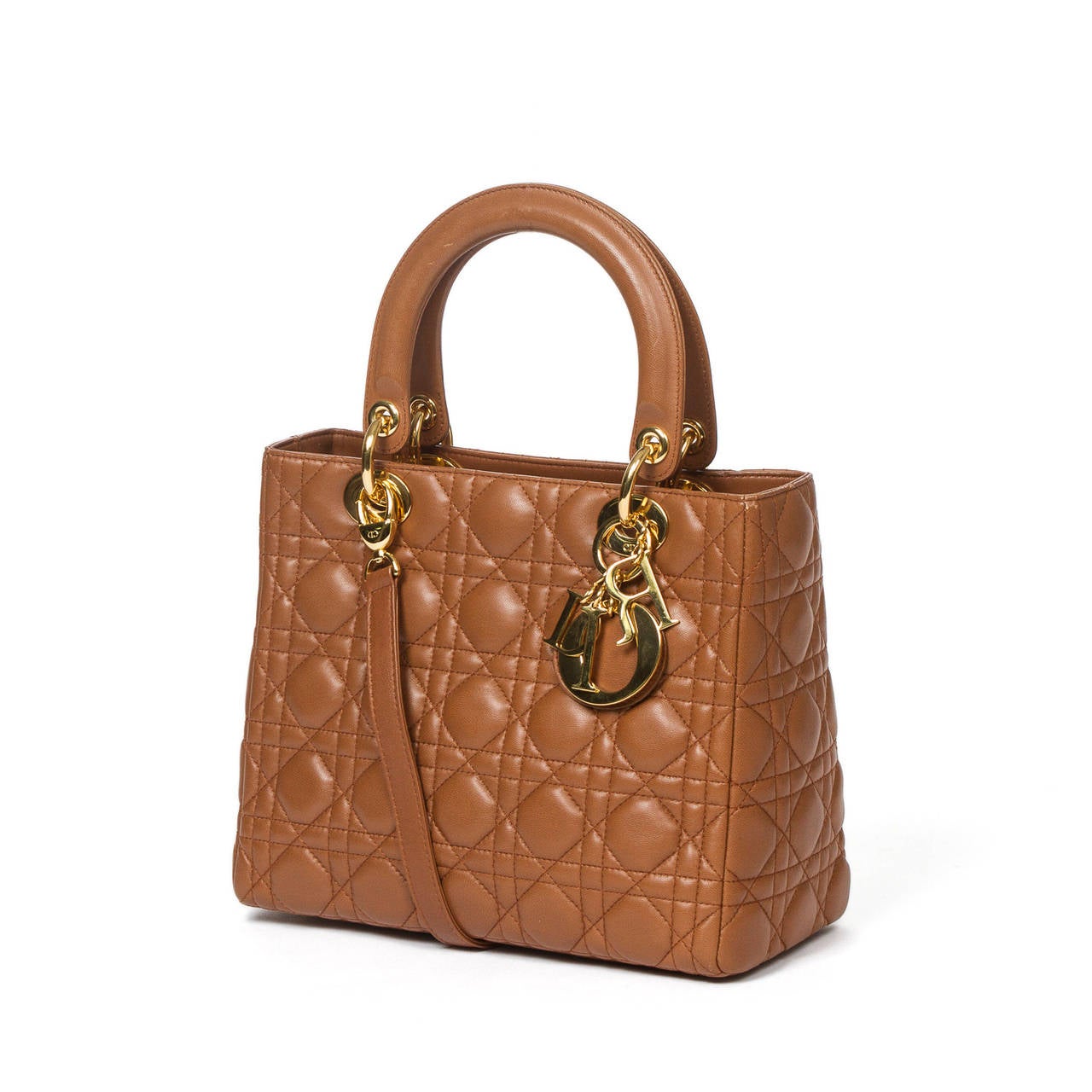 Lady Dior MM in honey brown cannage leather with shoulder strap and gold tone hardware. Brown jacquard canvas interior with one zip pocket. Instruction care booklet included.  Perfect Condition, minor scuffs on the corners and on the handles.