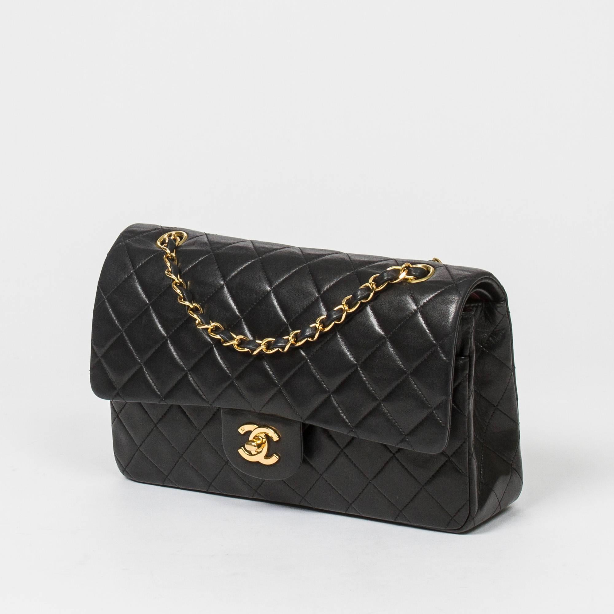 Classic Double Flap 26cm in black quilted lambskin with double chain strap interlaced with leather, gold tone CC turnlock. Back slip pocket. Burgundy leather lined interior with 3 compartments. Gold tone 