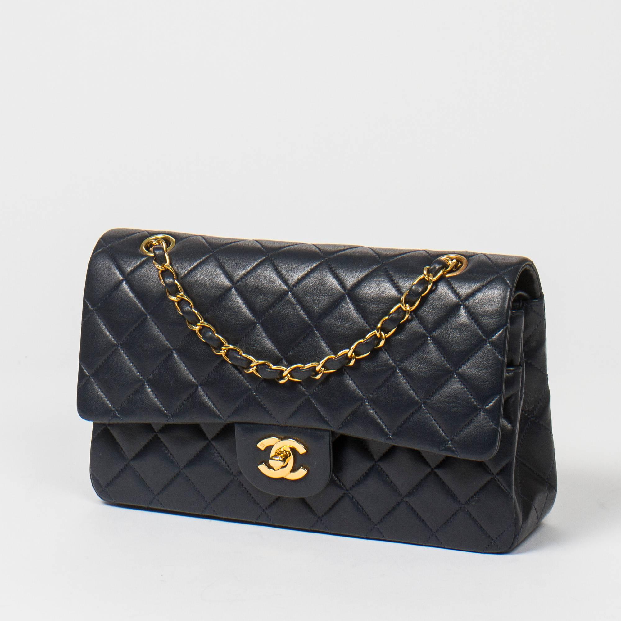 Classic Double Flap 26cm in navy quilted lambskin with double chain strap interlaced with leather, gold tone CC turnlock. Back slip pocket. Navy leather lined interior with 3 compartments. Gold tone 