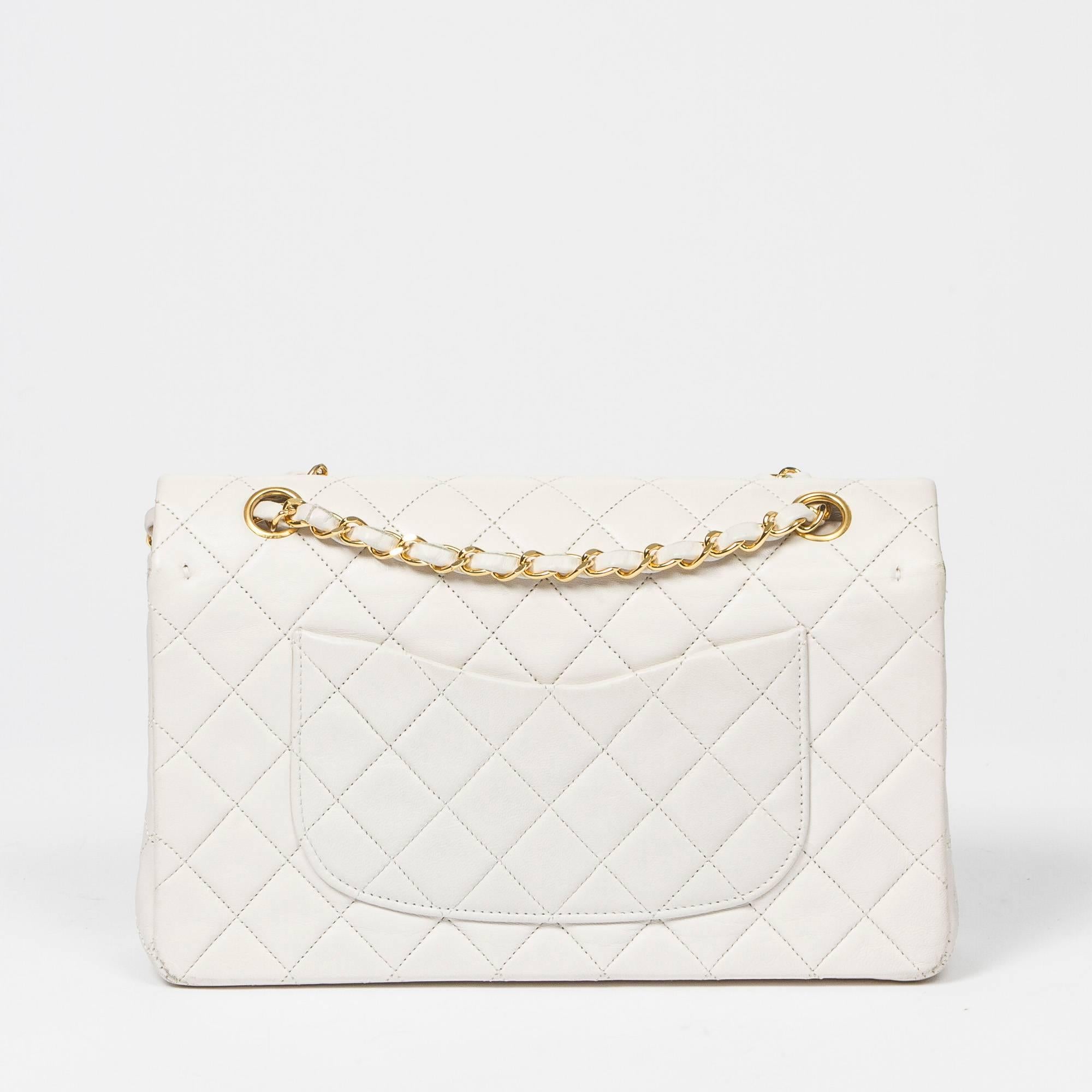 Classic Double Flap 26 in white quilted lambskin, double chain strap interlaced with leather, signature turnlock closure, gold tone hardware. Back slip pocket. White leather lined interior with 3 slip pockets. Gold tone heat stamps 
