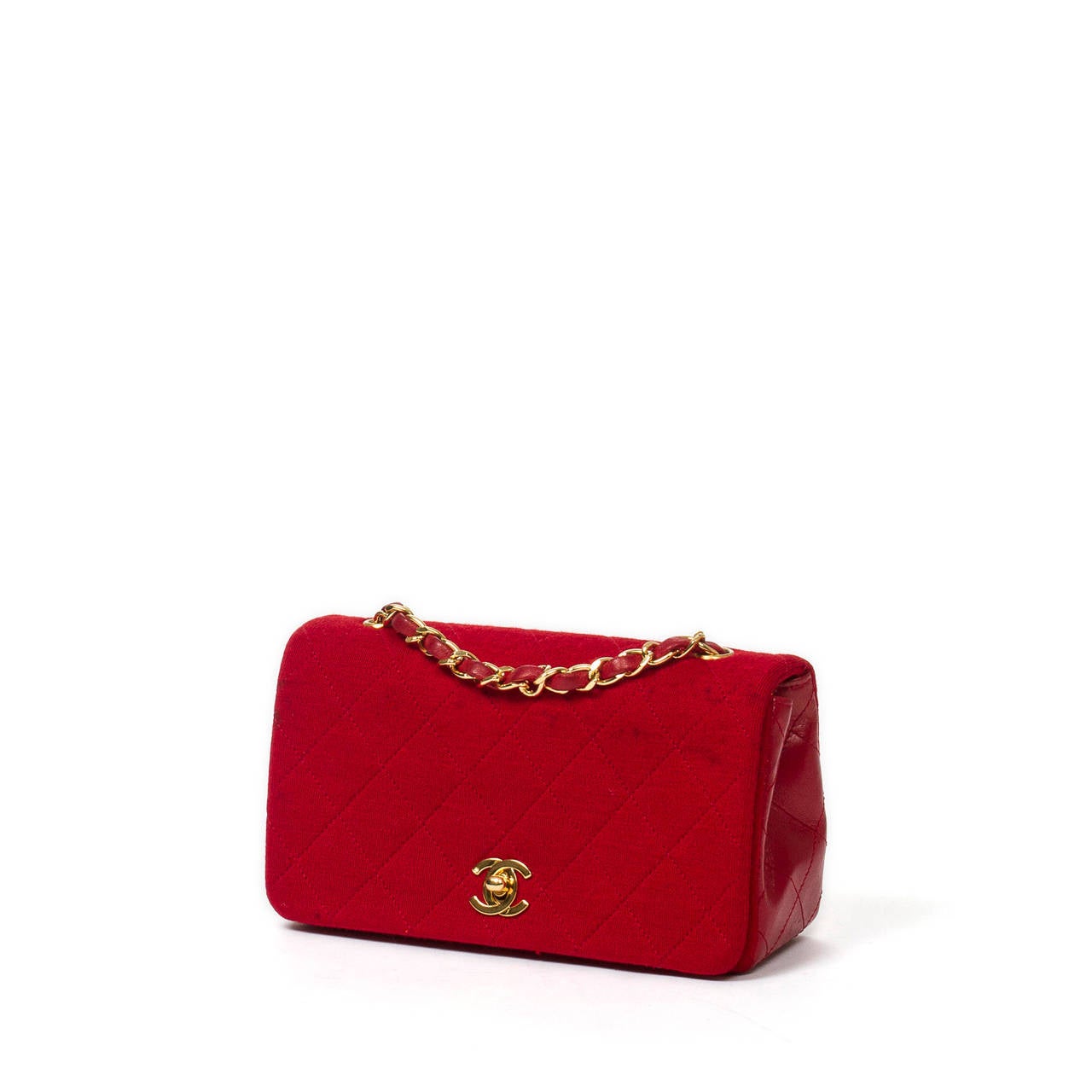 Chanel Vintage shoulder bag in red quilted jersey with red quilted leather sides, gold tone chain strap interlaced with red leather, CC turnlock. Red leather lined interior with 3 slip pockets. Box, dustbag, authenticity card and sticker included.