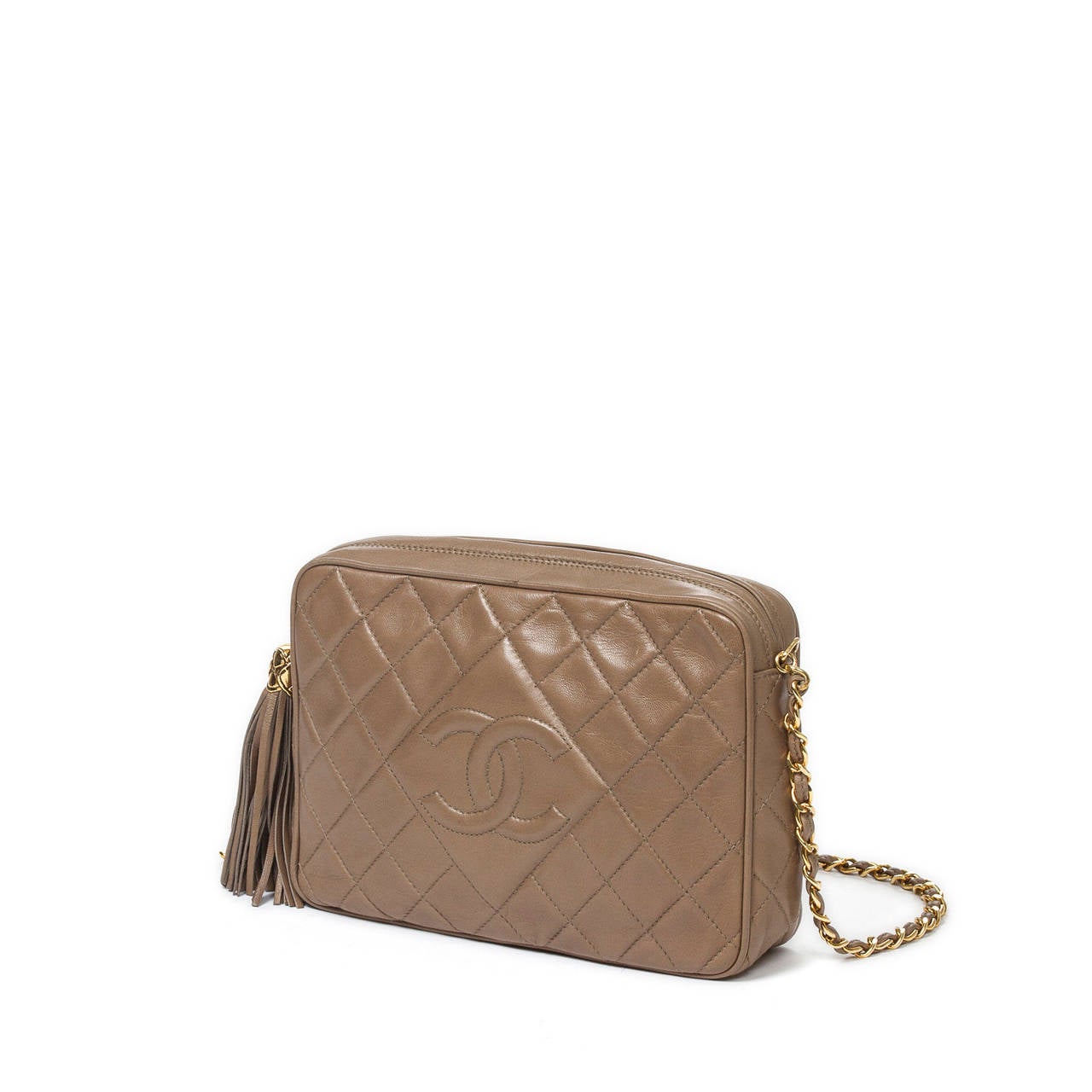 Vintage shoulder bag in taupe quilted leather with front CC, long chain strap interlaced with leather, leather tassel zipper toggle, gold tone hardware. Light brown leather interior with one zip pocket. Dustbag, authenticity sticker and card