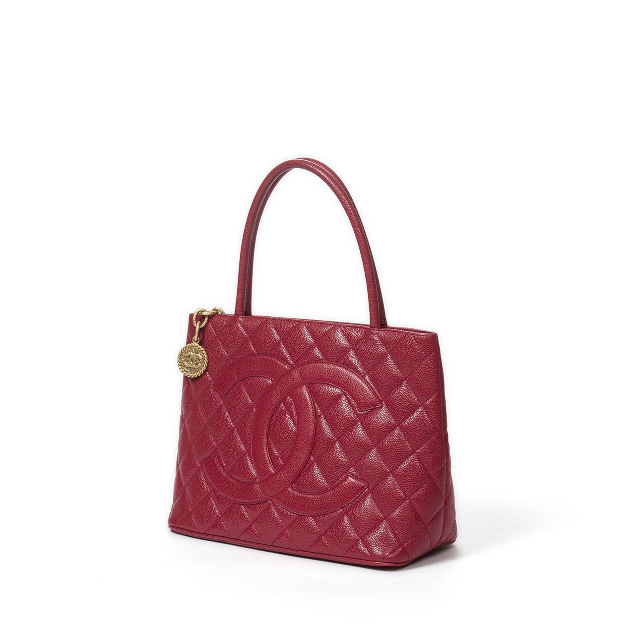 Médaillon in red raspberry quilted caviar leather with brushed gold tone hardware. Red raspberry leather lining with one zip pocket and one slip pocket. Model from 2000-2002 (Code : 6386264). Box, dustbag, authenticity card and stitcker included.