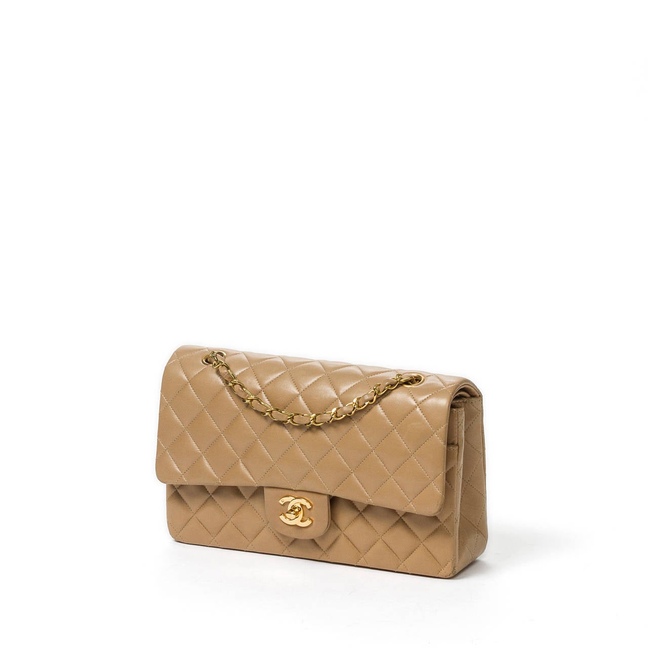 Classic double flap 26cm in beige quilted leather with double chain strap interlaced with beige leather, CC turnlock and gold tone hardware. Beige leather interior with 3 slip pockets and authenticity sticker. Model from 1994 to 1996 (Code :