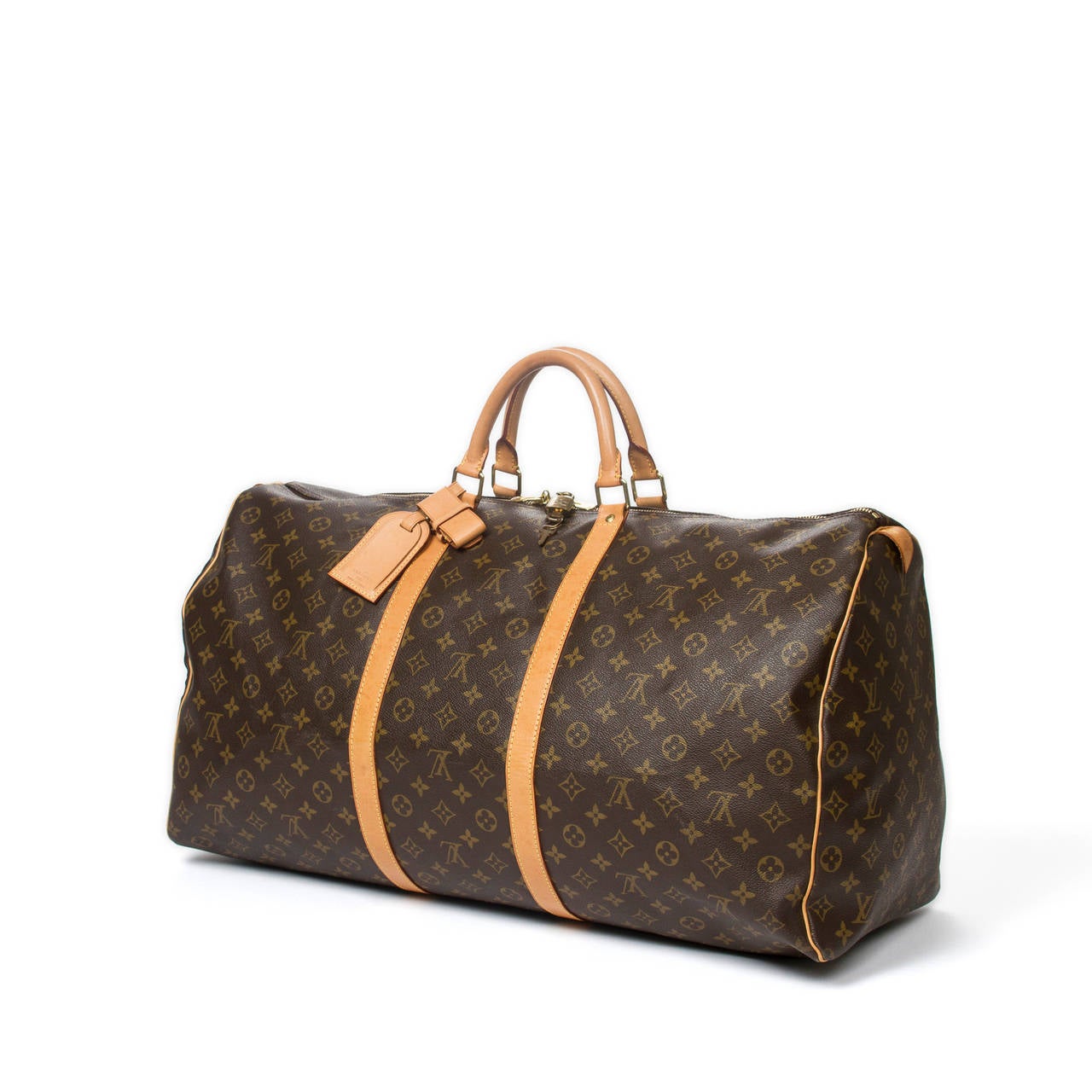 Louis Vuitton Keepall 60 in monogram canvas with vachetta leather handles, luggage tag, handle strap, cadenas and keys, golden brass hardware. Brown canvas lined interior. Model of 2001. Date Code FL0011. Beautiful patina on the leather, excellent