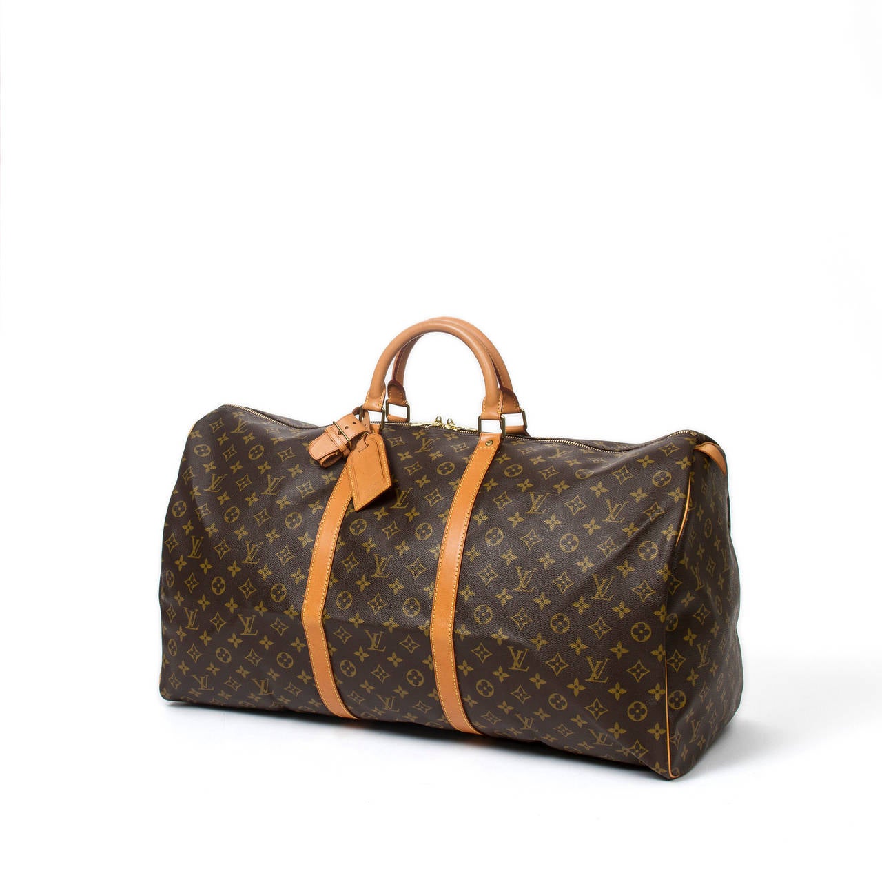 Keepall 60 in monogram canvas with vachetta leather handles, luggage tag, handle strap, cadenas and keys, golden brass hardware. Brown canvas lined interior. Beautiful patina on the leather, Excellent condition.