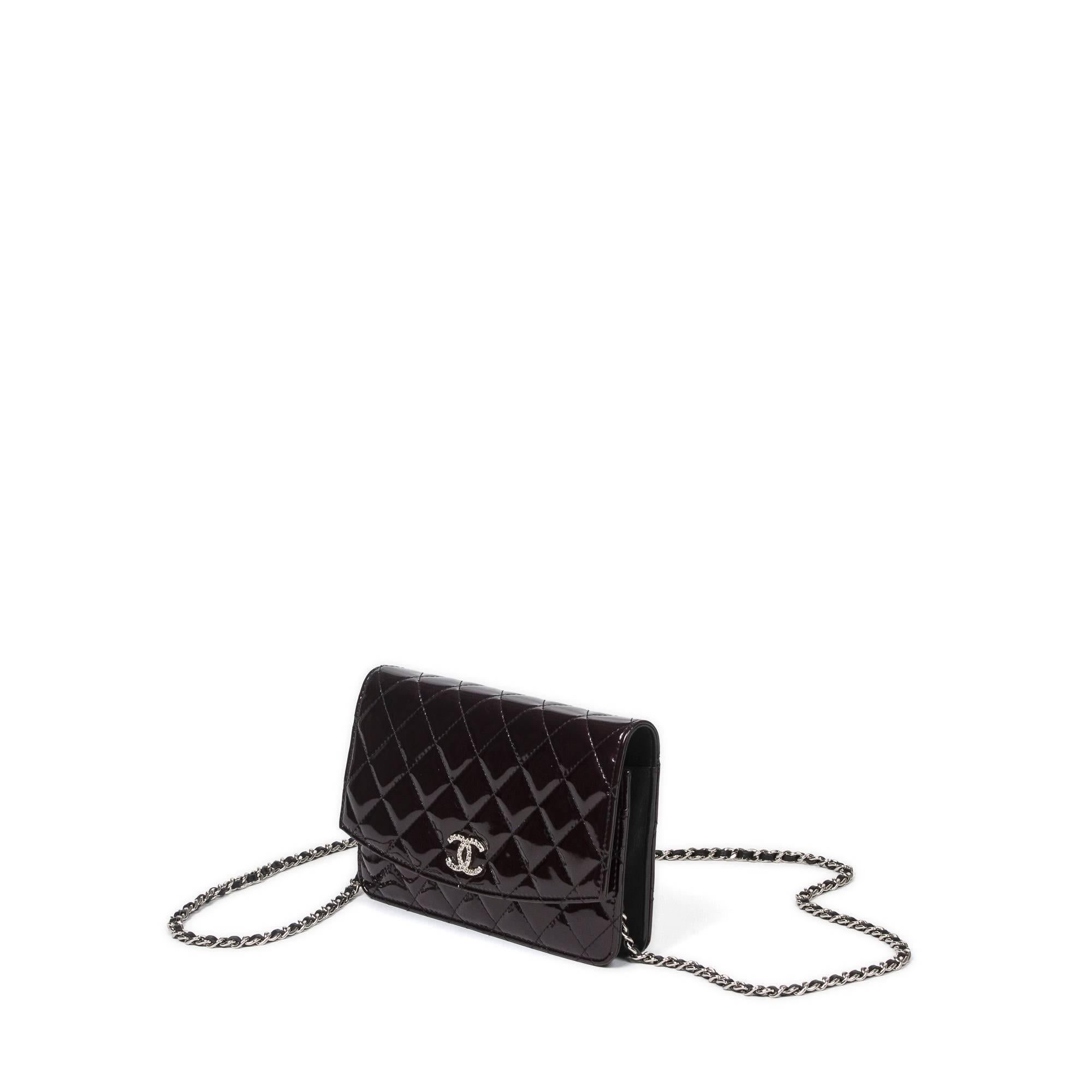 Chanel Wallet On Chain 19cm in black quilted patent leather with long chain strap interlaced with black leather (60cm), silver tone hardware. Snap button closure. Black canvas lined interior with 2 zip pockets, 2 slip pockets and 6 card slots.