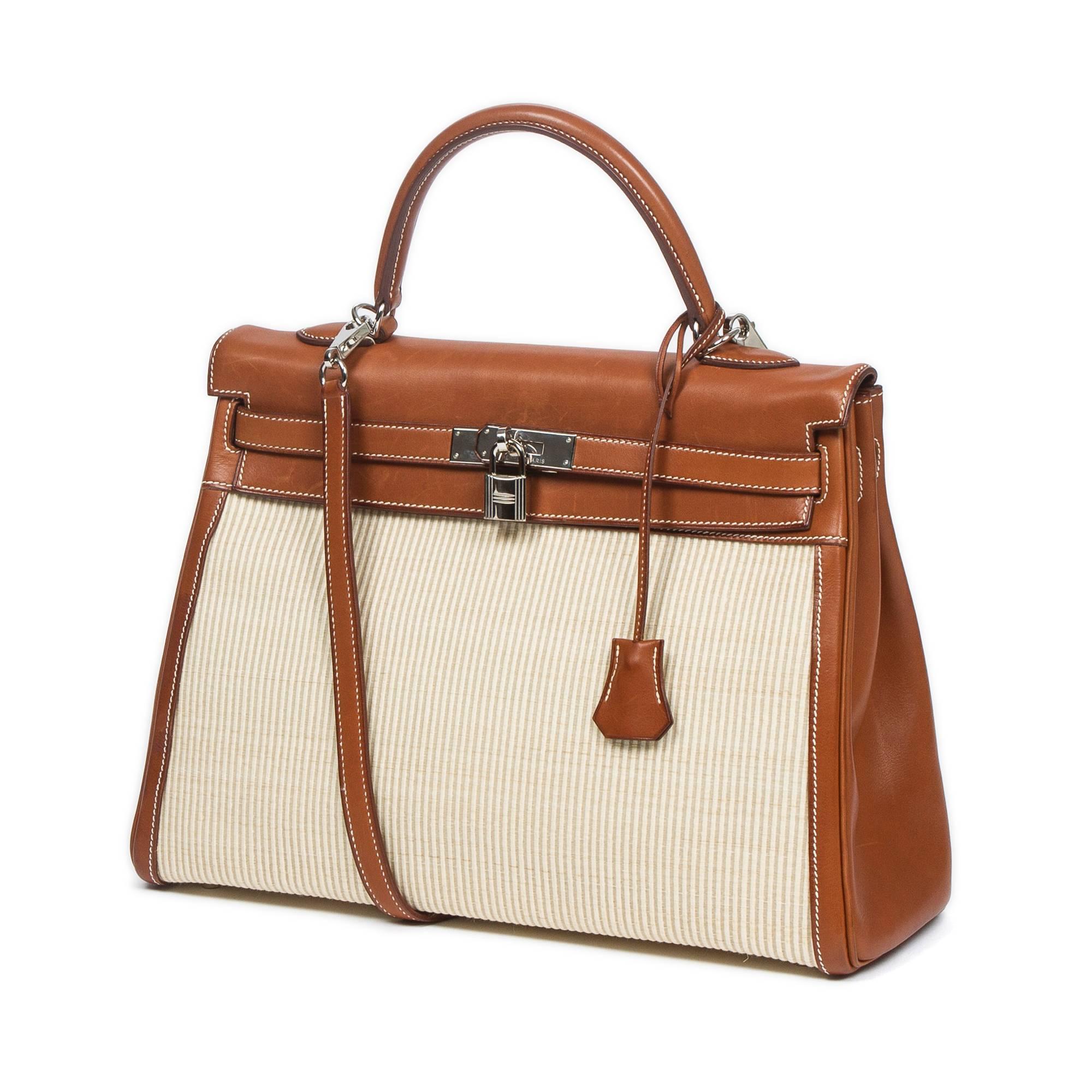 Kelly Retourné 35 in off white crinoline with flap, handle and details in barenia leather. Constrasting white stitchings and silver tone hardware. Barenia leather shoulder strap with cadenas and keys in clochette. Beige chevron canvas lined