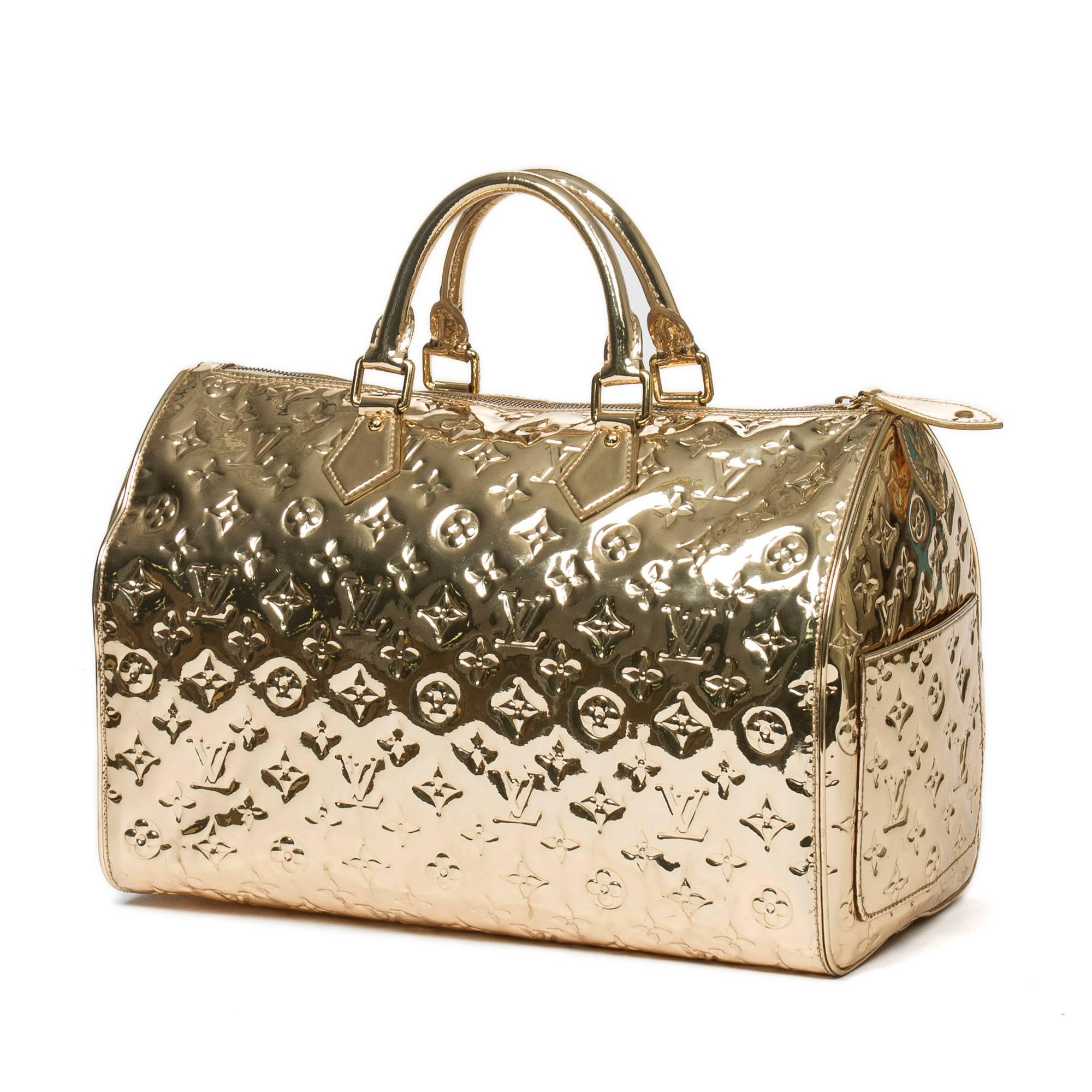Special Edition Speedy 35 in gold monogram mirror with gold tone hardware, cadenas and keys in clochette. One side slip pocket. Beige textile lined interior with 2 slip pockets. Date code FO0028. Model from 2008. Dustbag included. There are some
