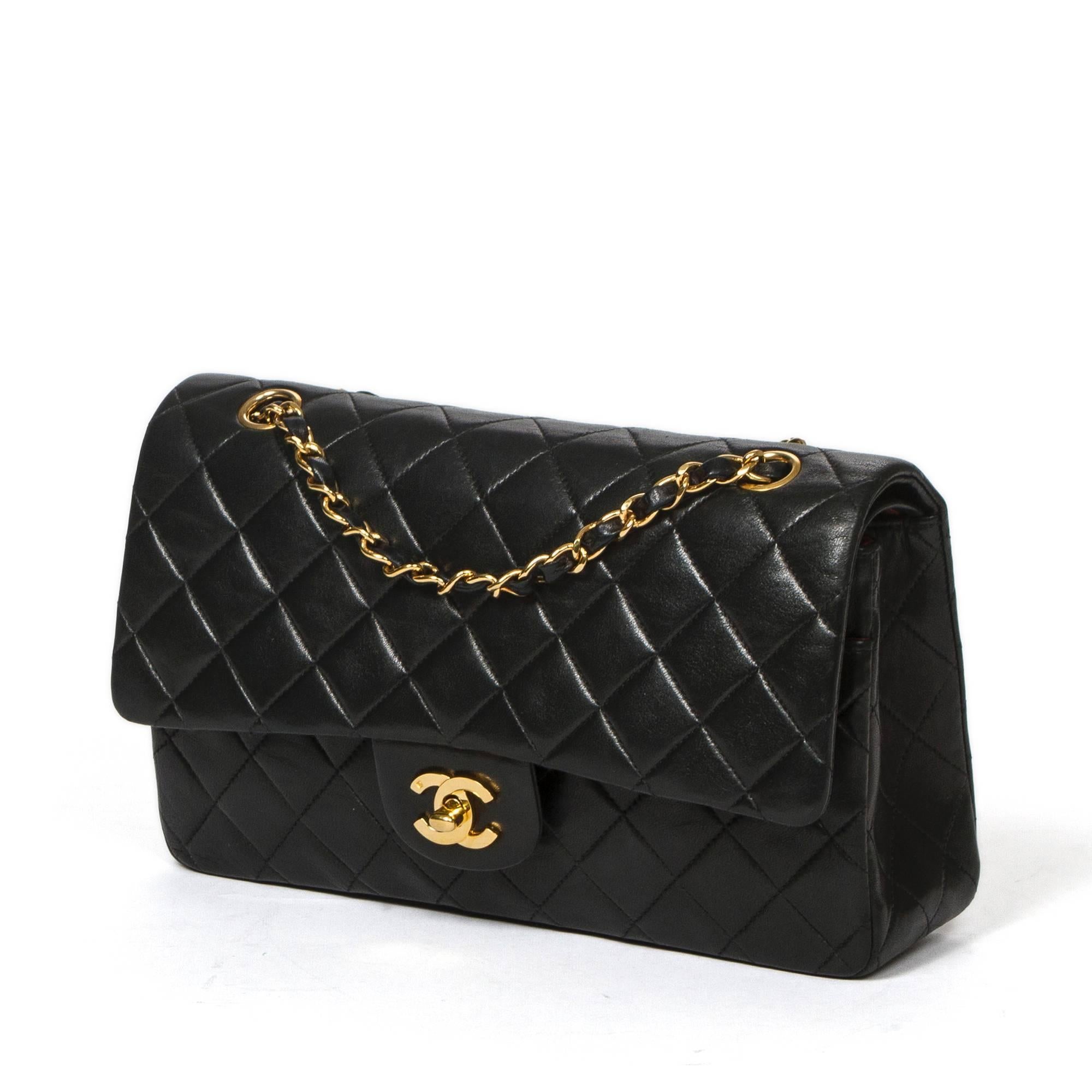 Classic Double Flap 26cm in black quilted lambskin with double chain strap interlaced with leather, gold tone CC turnlock. Back slip pocket. Burgundy leather lined interior with 3 compartments. Gold tone 