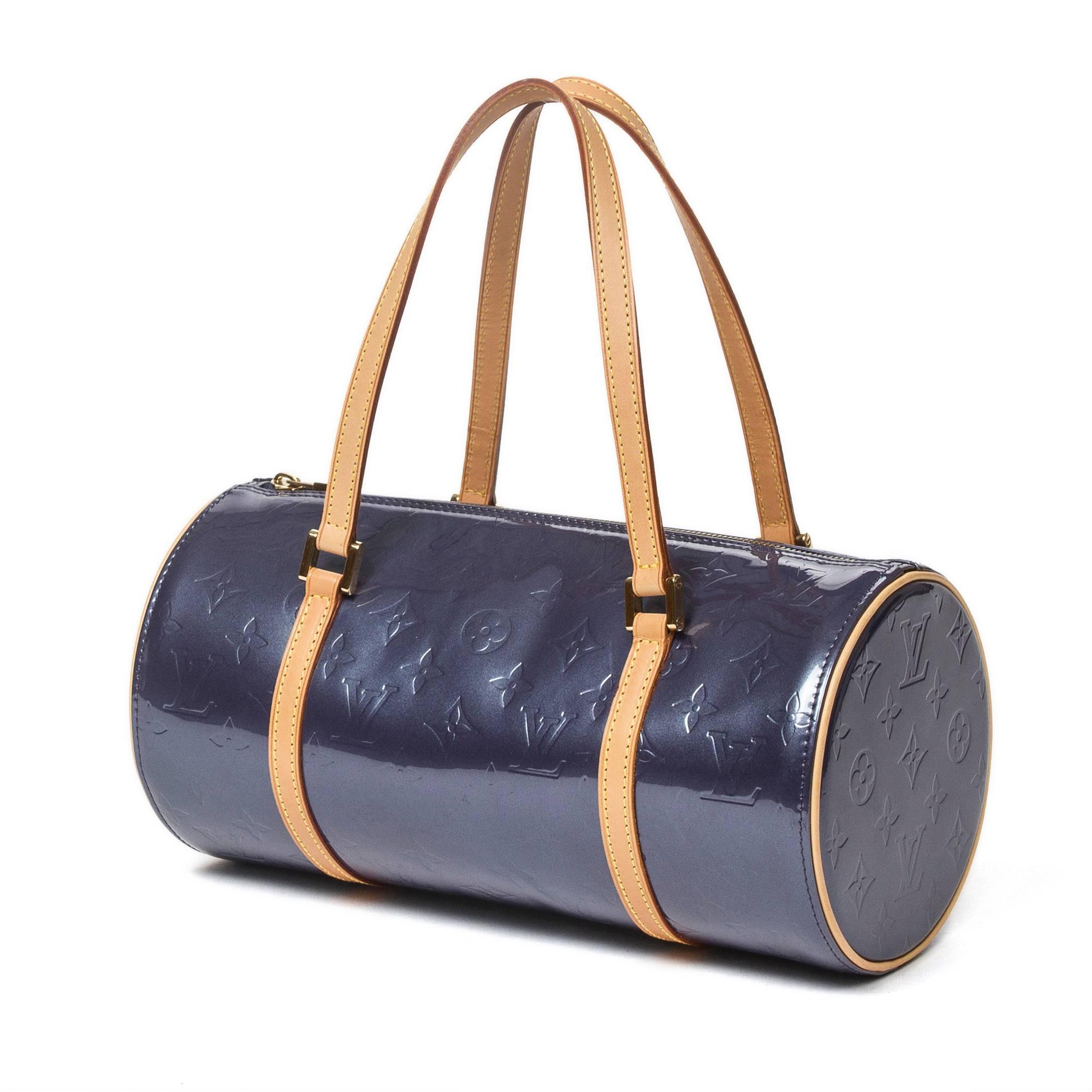 Bedford purple/blue in monogram vernis with vachetta leather handles and details, golden brass hardware. Side slip pocket. Zip closure. Purple/blue leather lined interior with 