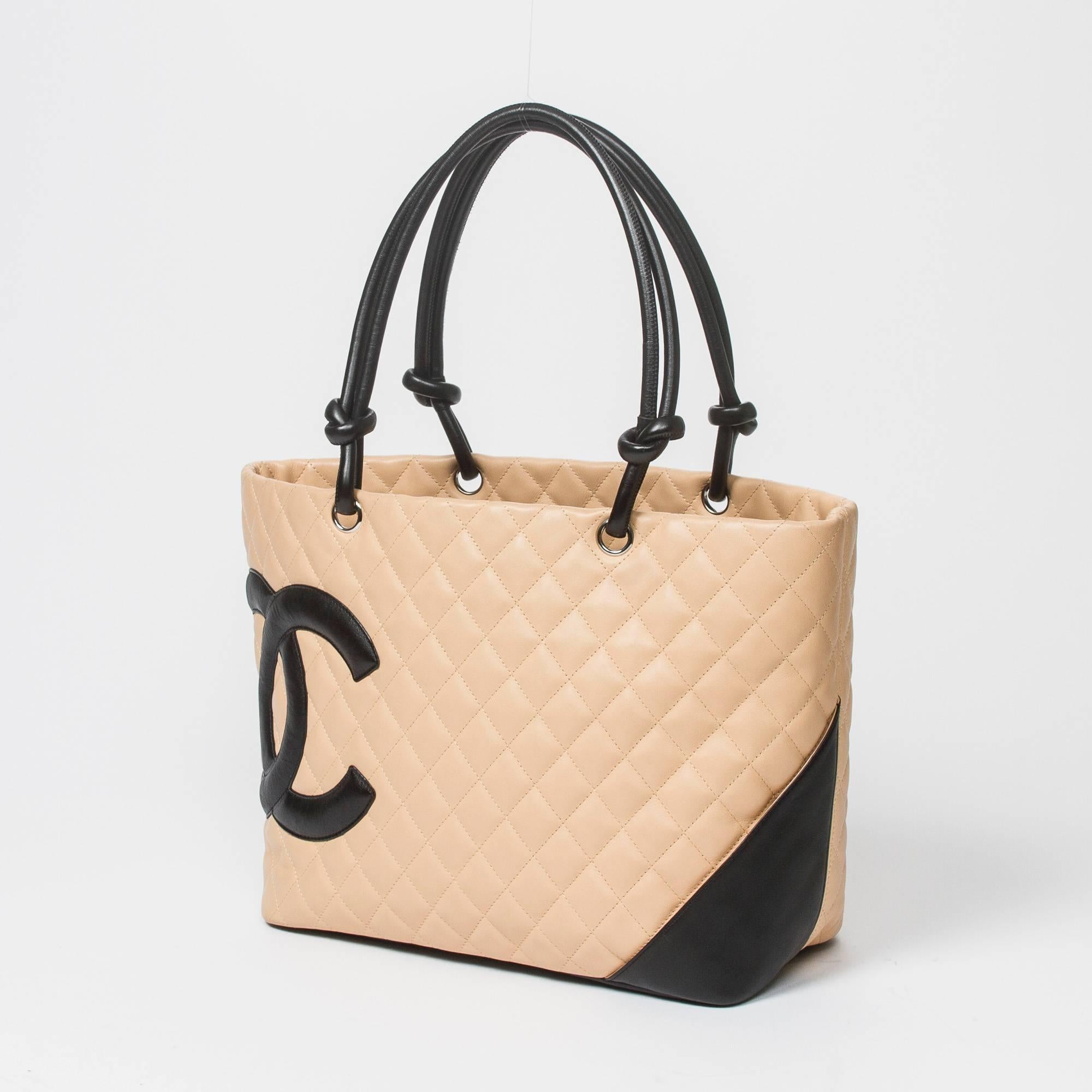 Cambon Tote GM in beige quilted leather with black leather CC, straps and details, silver tone hardware. Back slip pocket. 5 protective feet. Zip closure. Black jacquard canvas lined interior with one compartment, 2 zip pockets and lobster claw key