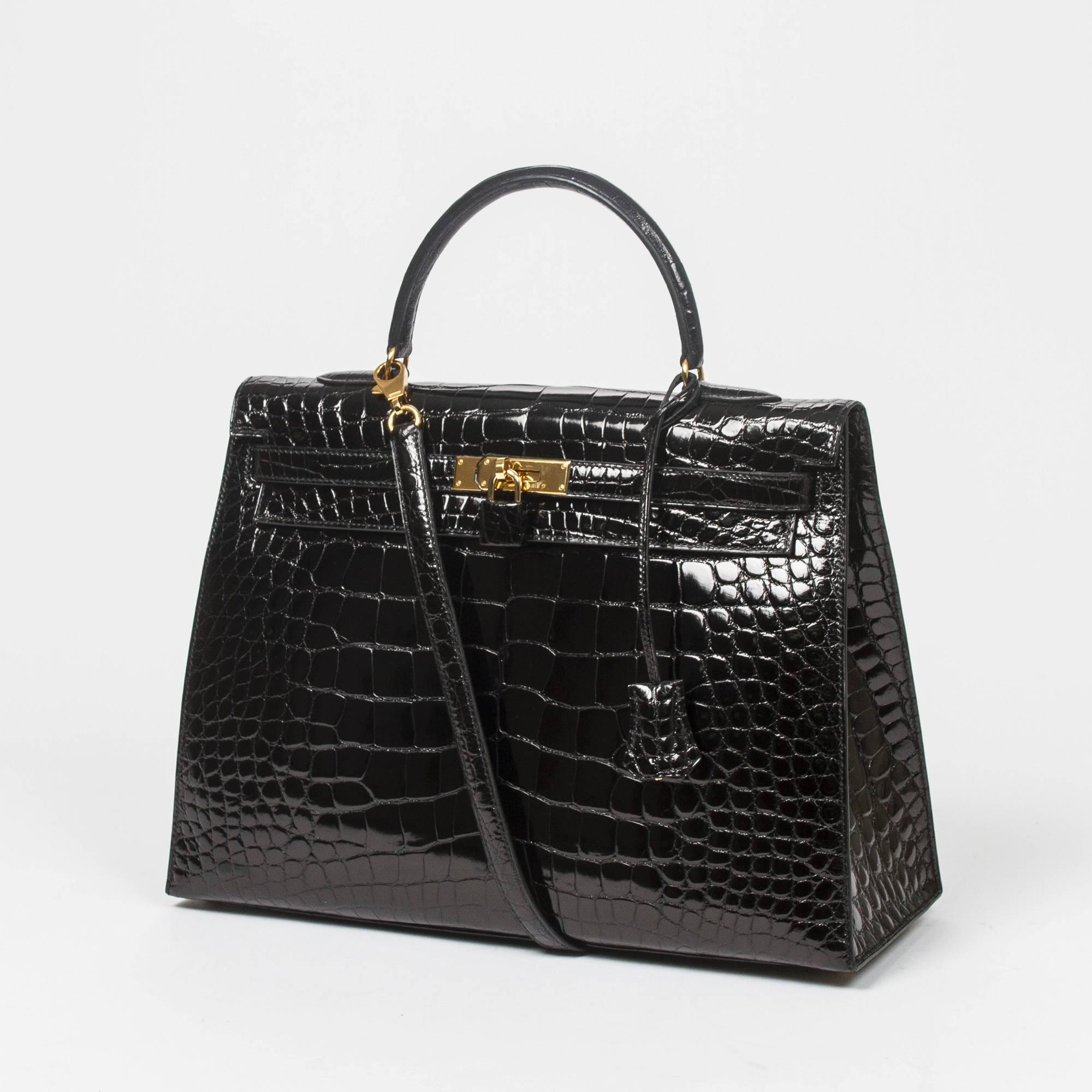 Kelly Sellier 35 in black alligator with strap, cadenas and keys in clochette, gold tone hardware. Interior lined in black chèvre leather with 2 slip pockets and one zip pocket. Stamp A in square. Model from 1997. Box and dustbag included. Gentle
