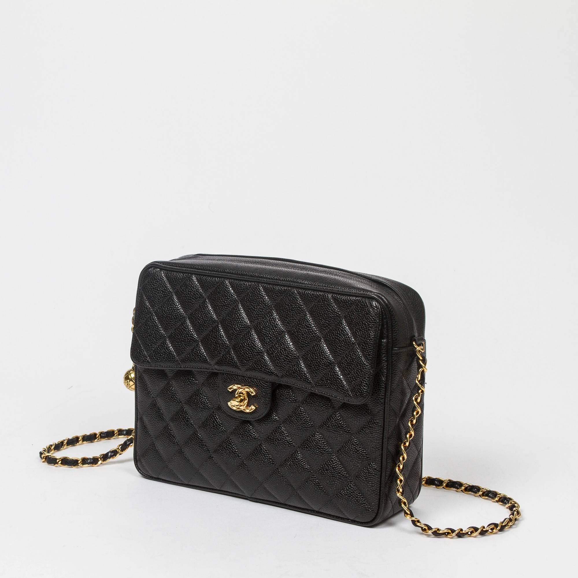 Vintage shoulder bag in black caviar quilted leather, one large front pocket with gold tone signature turnlock. Top zipper closure with gold tone sphere zipper toggle. Black leather lined interior with one zip pocket and one slip pocket. 