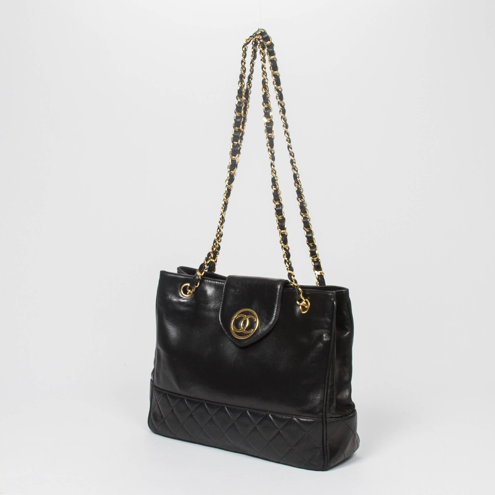 Vintage Tote shoulder bag in black leather with quilted base, chain straps interlaced with leather and gold tone hardware. Magnetic closures. Black leatherette lined interior with 2 zip pockets. 