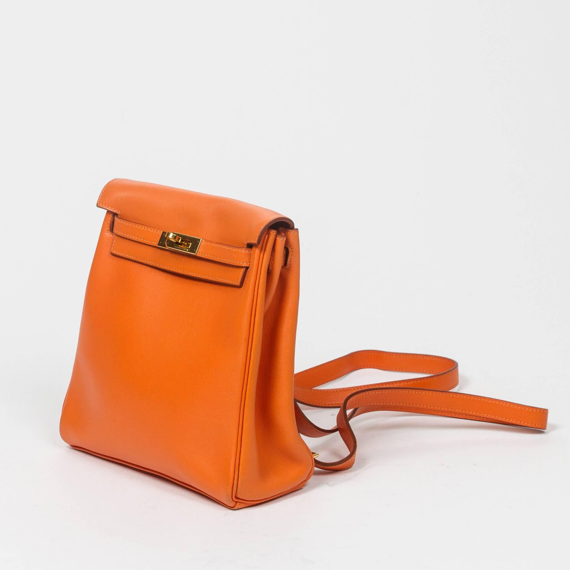 Kelly Ado PM in orange Gulliver leather with adjustable straps and gold tone hardware. Orange Gulliver leather lined interior with one slip pocket. Stamp A in square. Model from 1997. Dustbag included. Some scuffs on leather at the corners and on