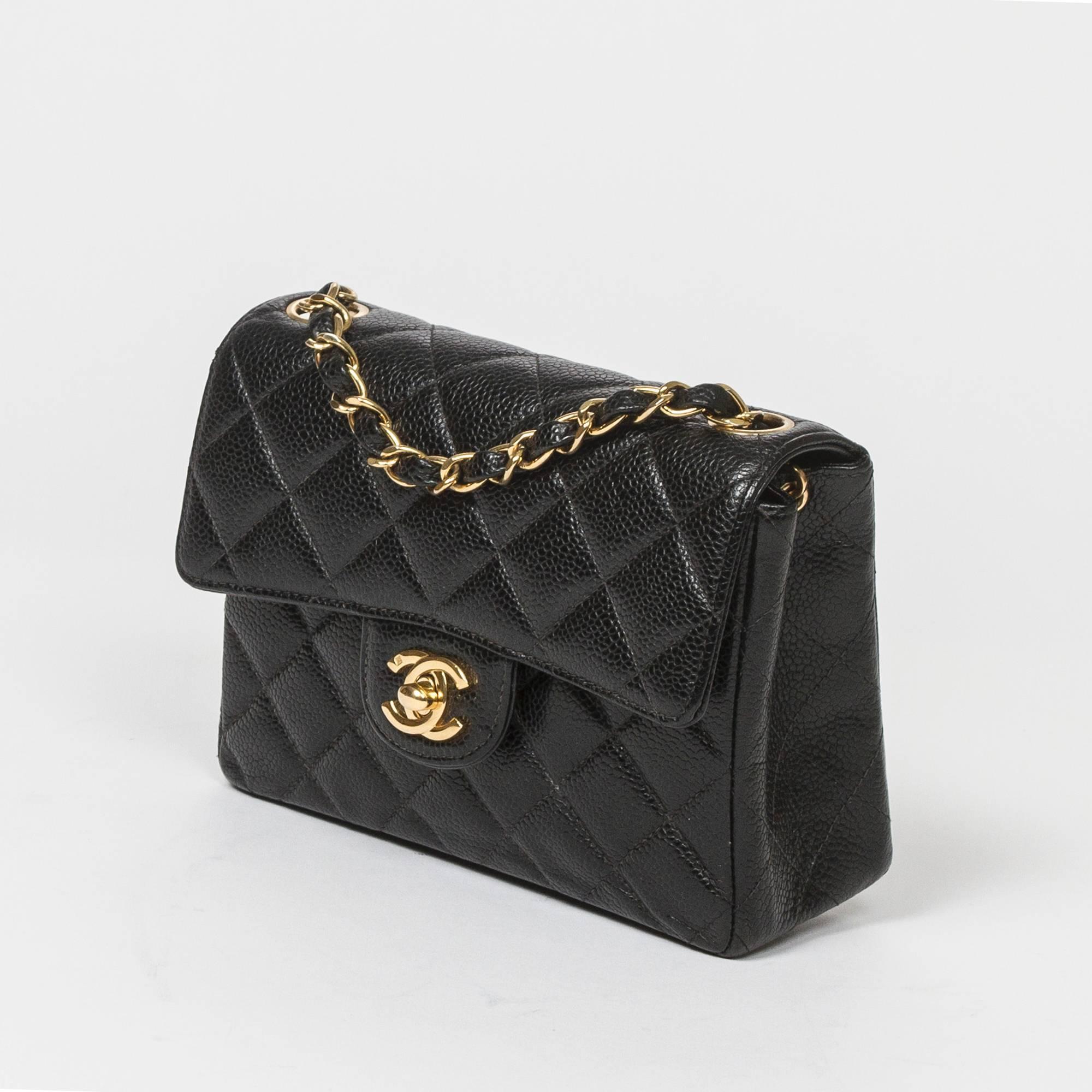 Classic Mini Flap Bag in black quilted caviar leather with long chain strap interlaced with black leather and signature CC turlock, gold hardware. Back slip pocket. Black leather lined interior with one slip pocket and zip pocket. Gold tone heat