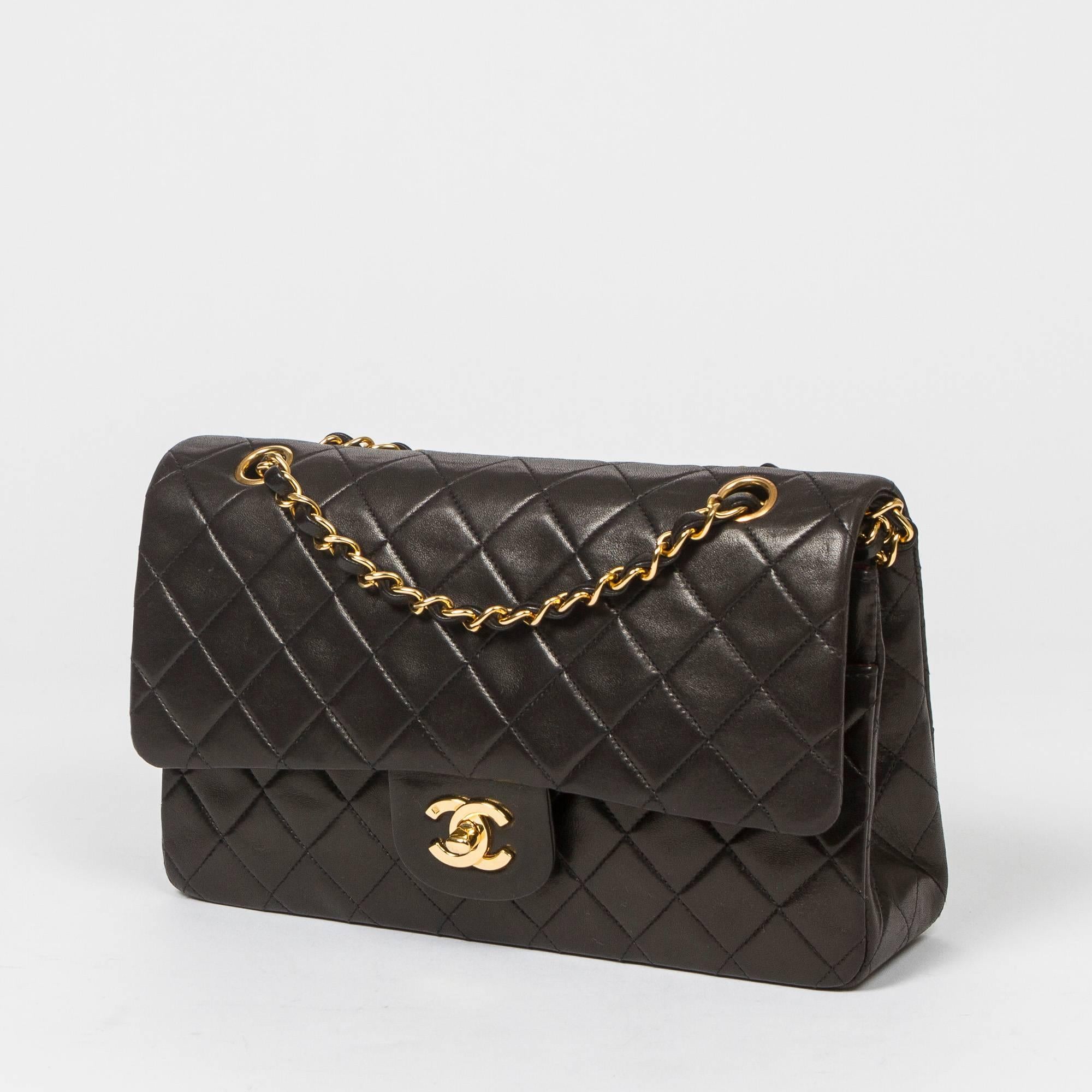 Classic Double Flap 26cm in black quilted lambskin with double chain strap interlaced with leather, gold tone CC turnlock. Back slip pocket. Burgundy leather lined interior with 3 compartments. Gold tone 